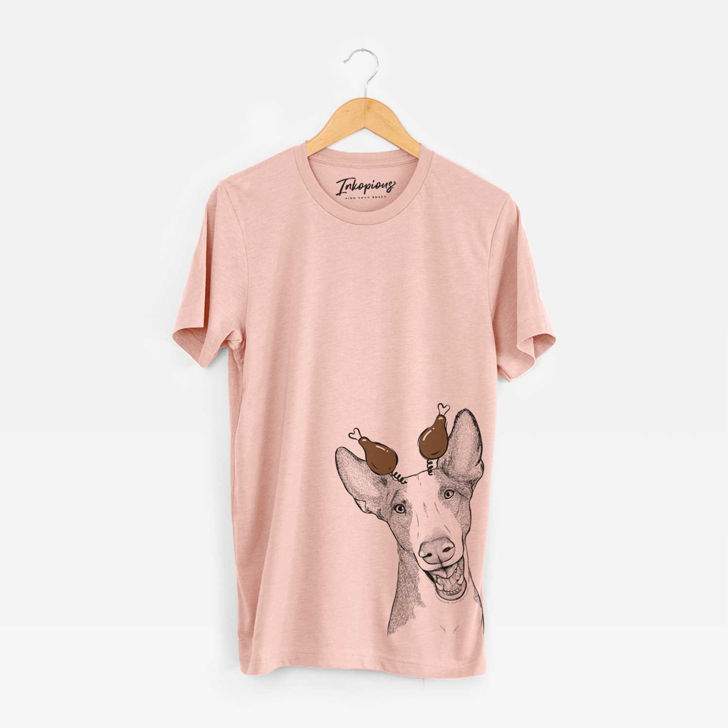 Hand-drawn sketch of Havok the Ibizan Hound with a Thanksgiving turkey headpiece on a Peach Unisex crewneck