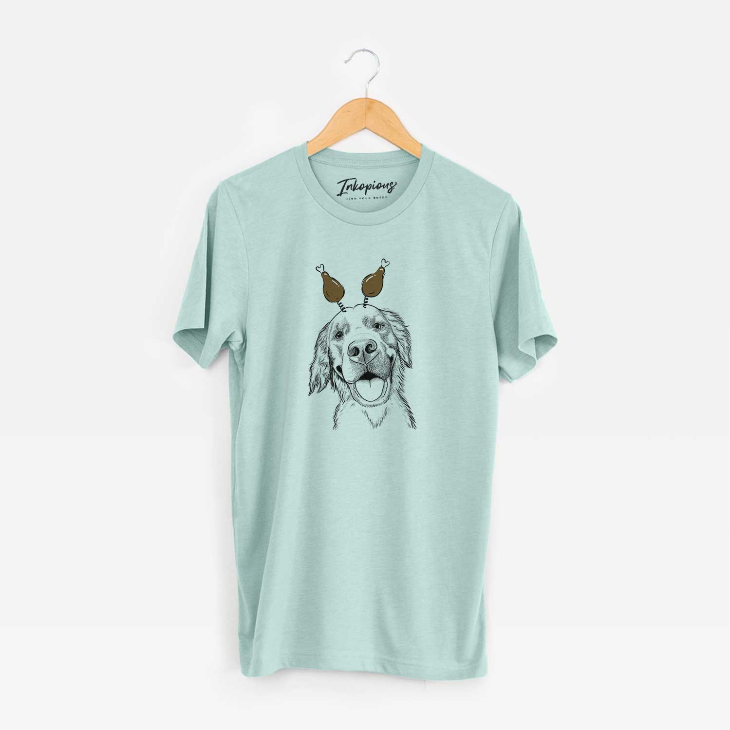 Hand-drawn sketch of Jordy the Golden Retriever with a Thanksgiving turkey headpiece on a Heather Sage Unisex crewneck