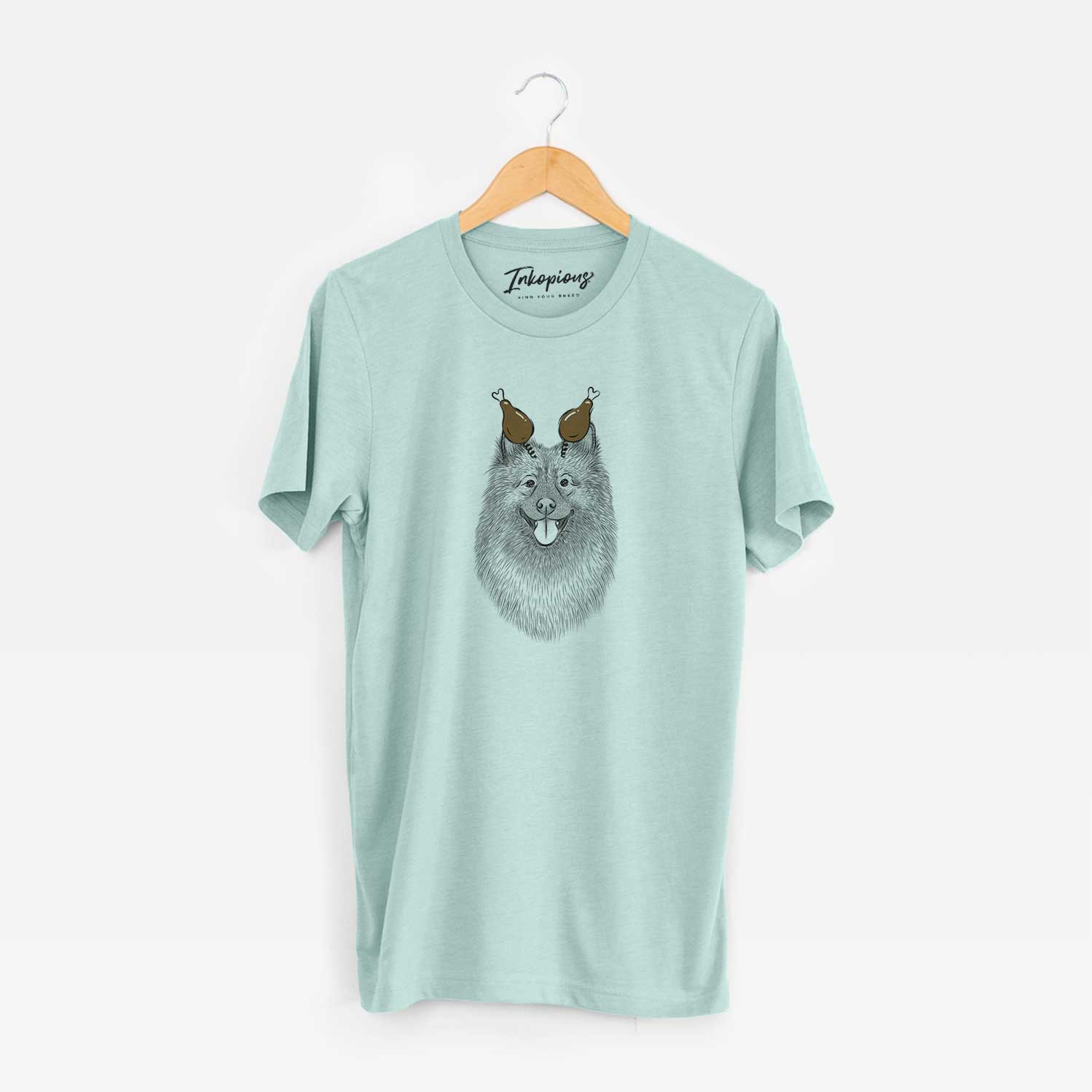 Hand-drawn sketch of Kai the Keeshond with a Thanksgiving turkey headpiece on a Heather Sage Unisex crewneck