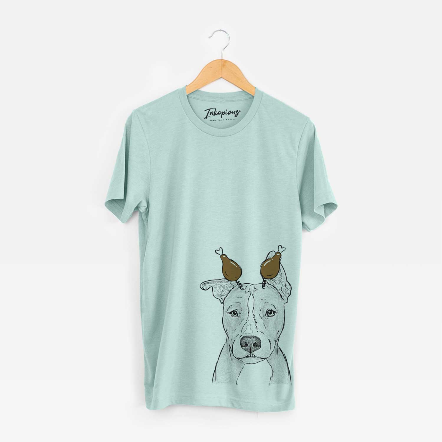 Hand-drawn sketch of Kisses the Pitbull with a Thanksgiving turkey headpiece on a Heather Sage Unisex crewneck