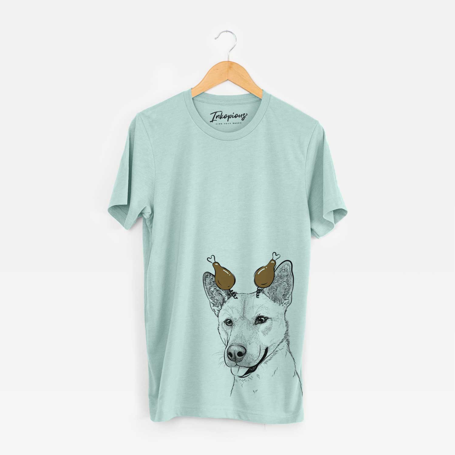 Hand-drawn sketch of Kulfi the Jindo Shiba Inu Mix with a Thanksgiving turkey headpiece on a Heather Sage Unisex crewneck