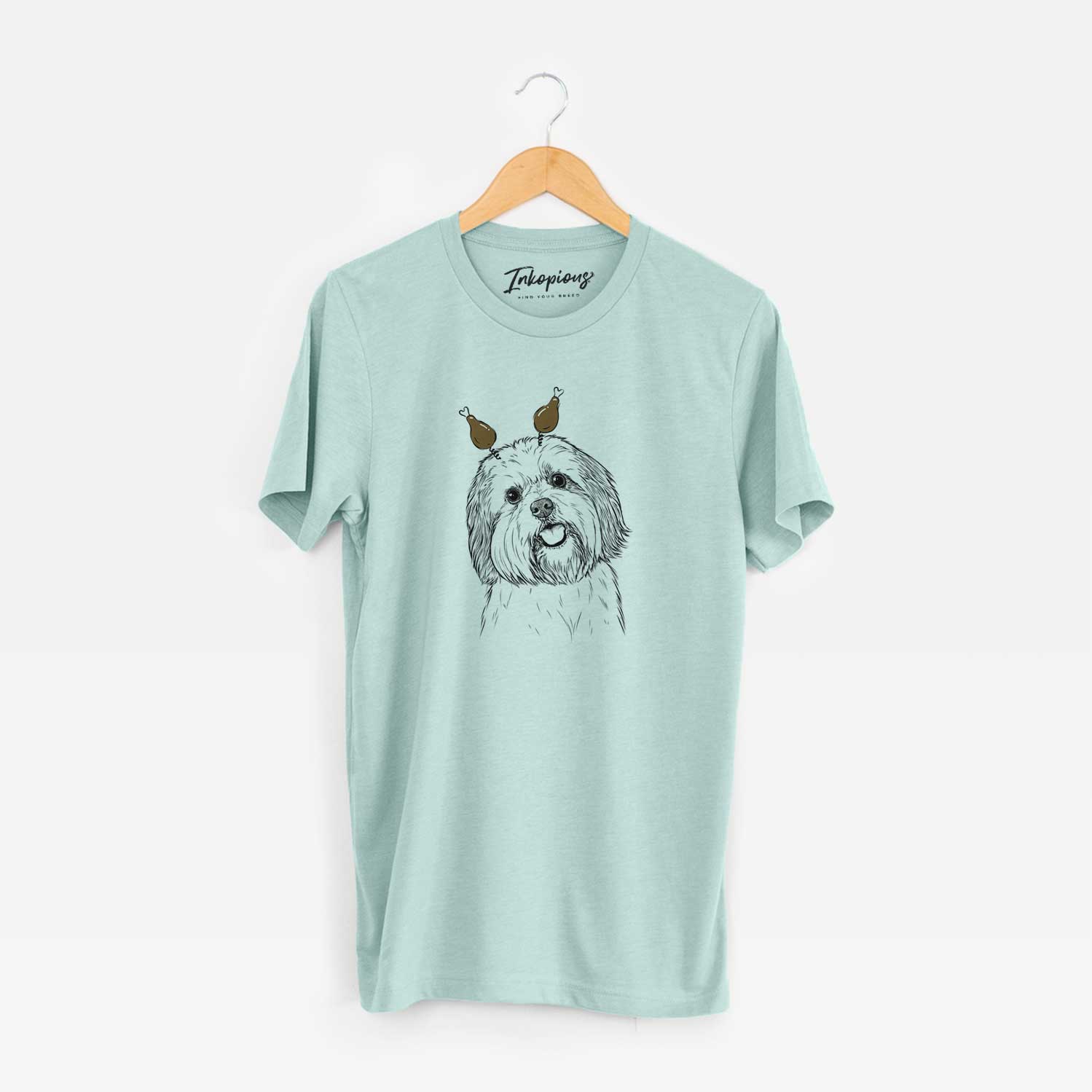 Hand-drawn sketch of Nikka the Lowchen with a Thanksgiving turkey headpiece on a Heather Sage Unisex crewneck