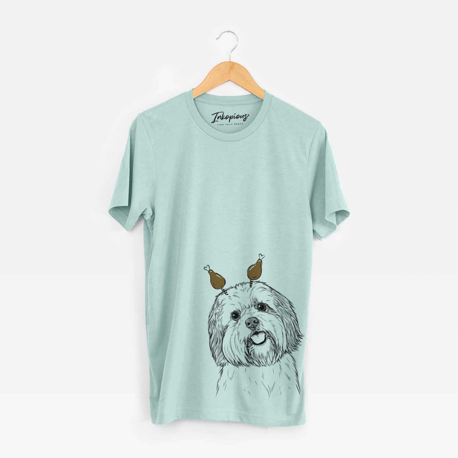 Hand-drawn sketch of Nikka the Lowchen with a Thanksgiving turkey headpiece on a Heather Sage Unisex crewneck