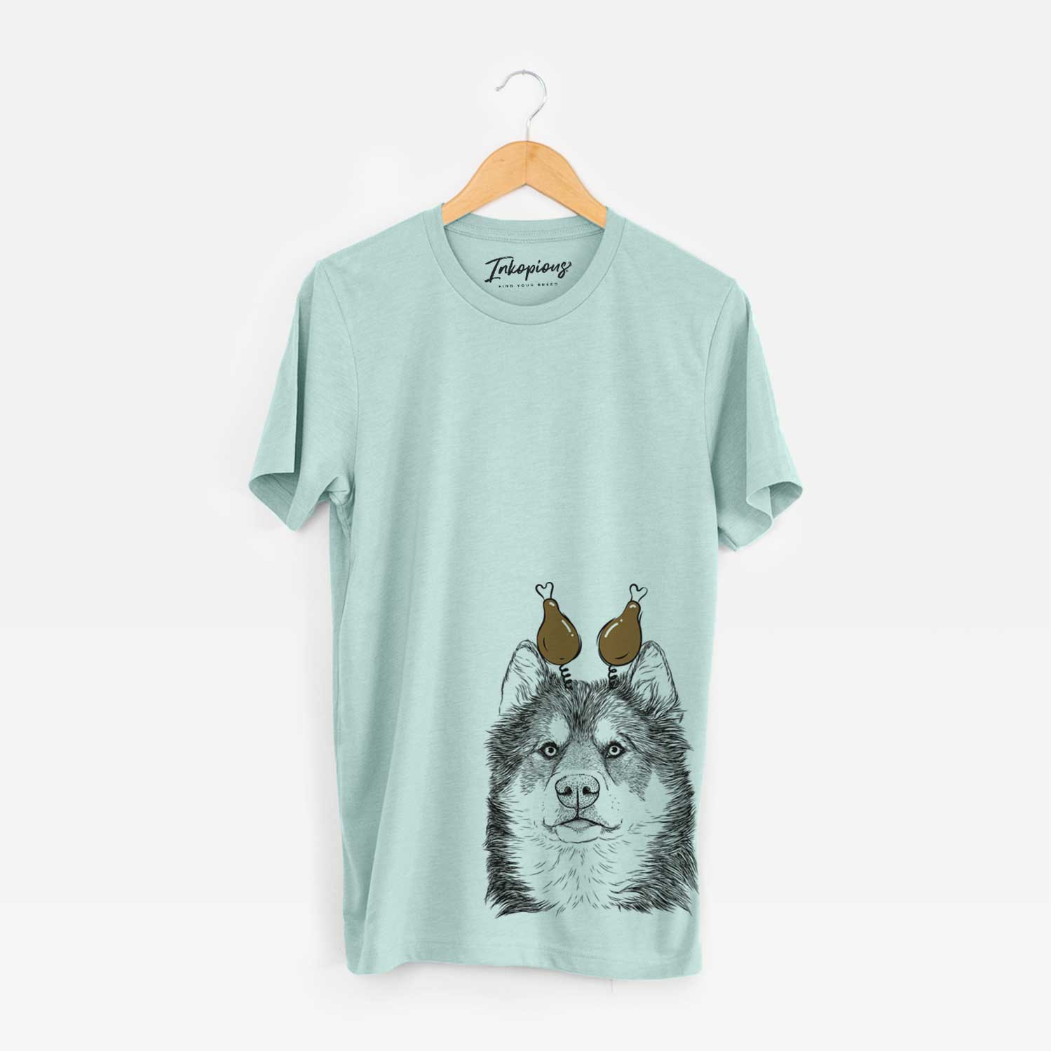 Hand-drawn sketch of Oskar the Canadian Eskimo Dog with a Thanksgiving turkey headpiece on a Heather Sage Unisex crewneck