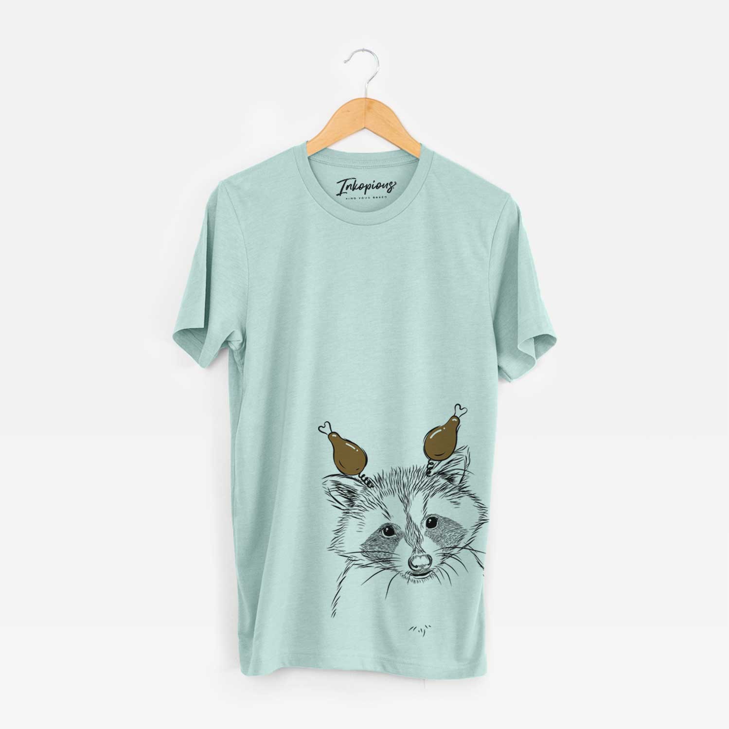 Hand-drawn sketch of Randy the Raccoon with a Thanksgiving turkey headpiece on a Heather Sage Unisex crewneck