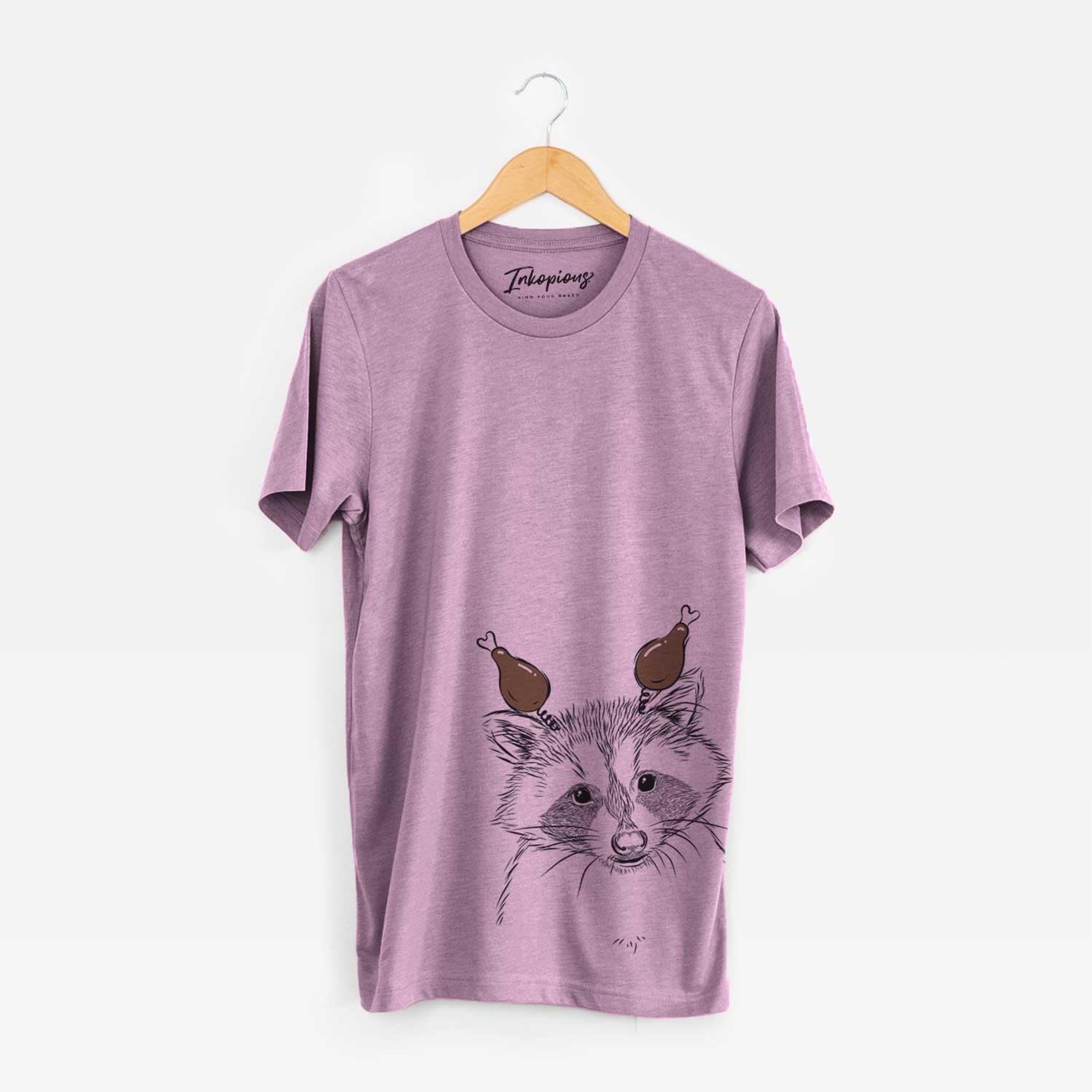 Hand-drawn sketch of Randy the Raccoon with a Thanksgiving turkey headpiece on an Orchid Unisex crewneck