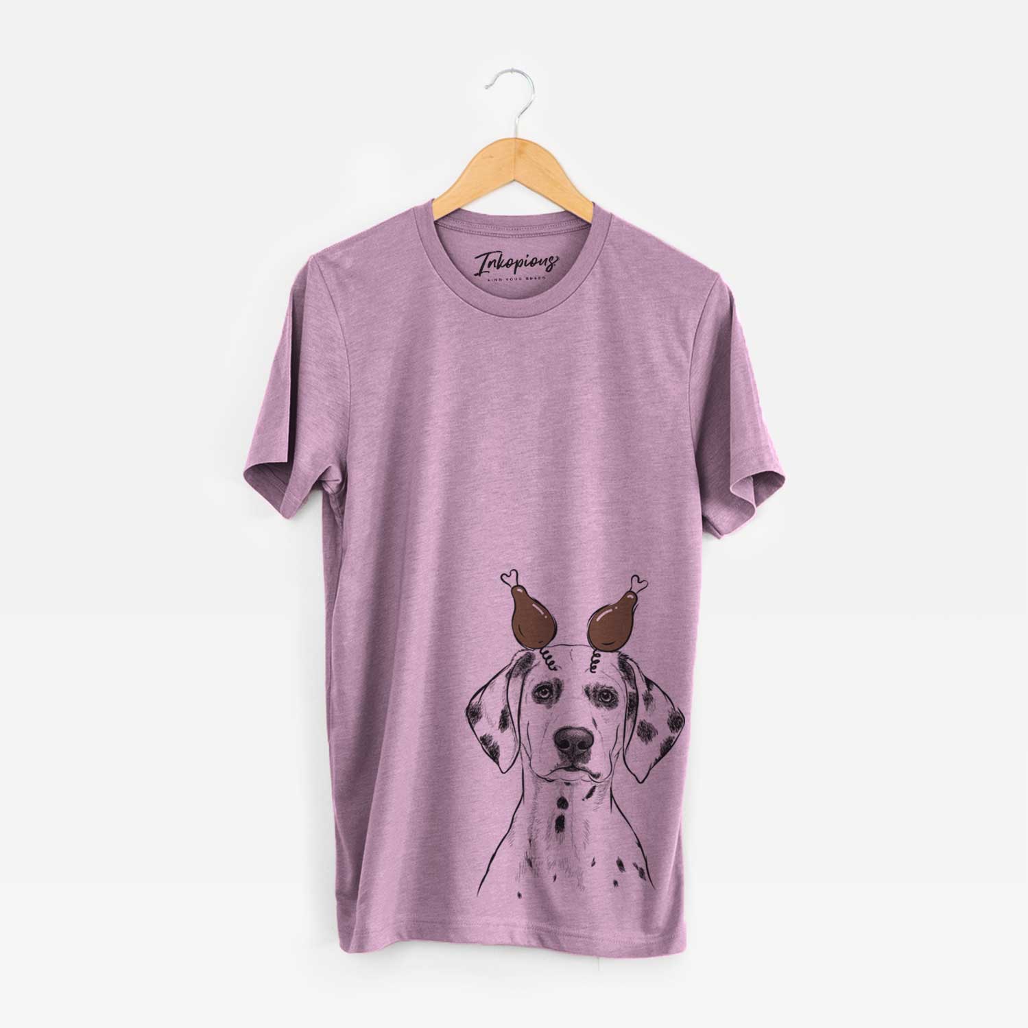 Hand-drawn sketch of Riot the Dalmatian with a Thanksgiving turkey headpiece on an Orchid Unisex crewneck