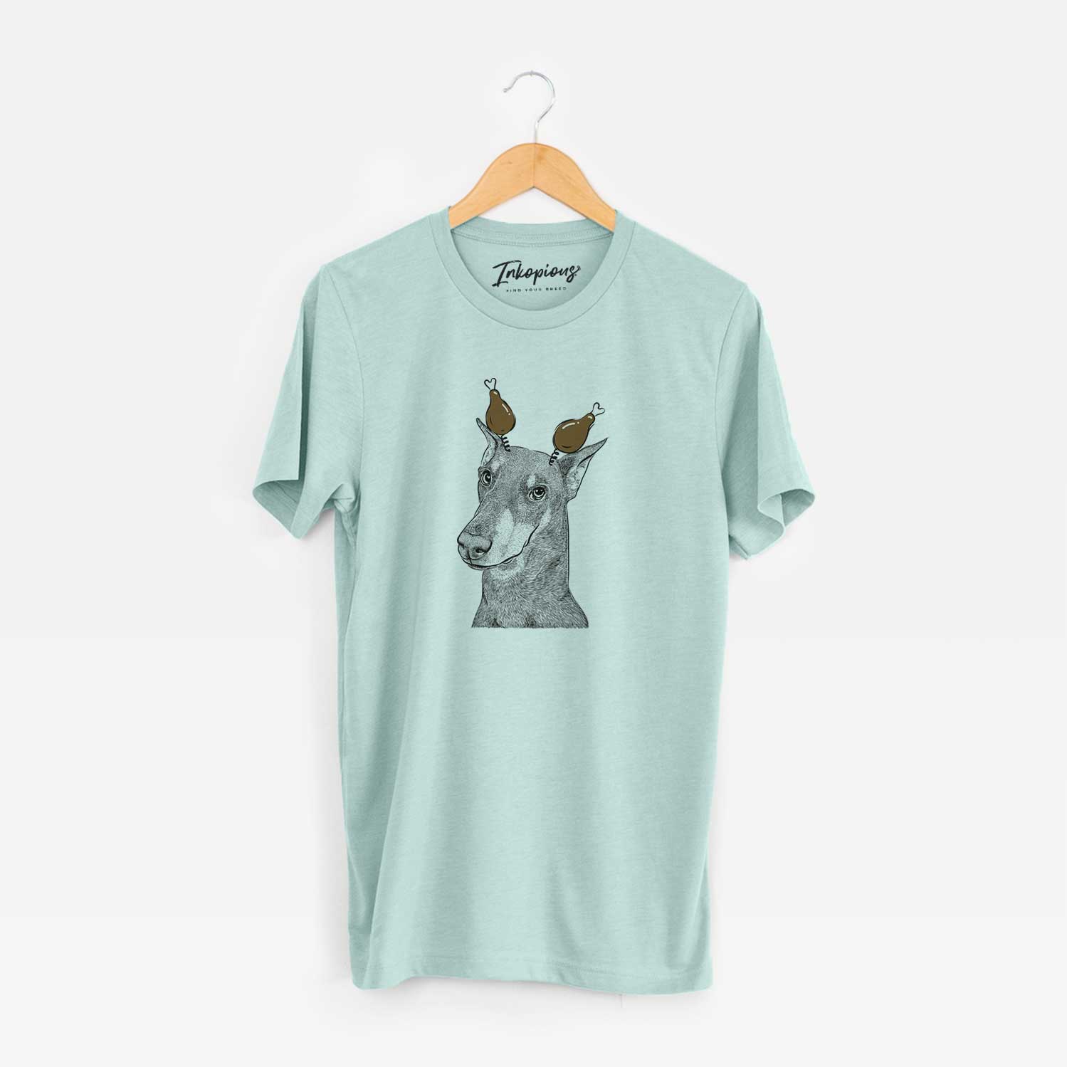 Hand-drawn sketch of Shelby the Doberman Pinscher with a Thanksgiving turkey headpiece on a Heather Sage Unisex crewneck