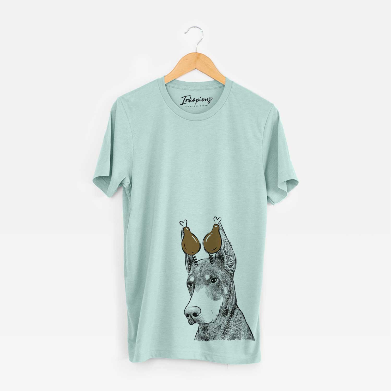 Hand-drawn sketch of Sunny the Doberman Pinscher with a Thanksgiving turkey headpiece on a Heather Sage Unisex crewneck
