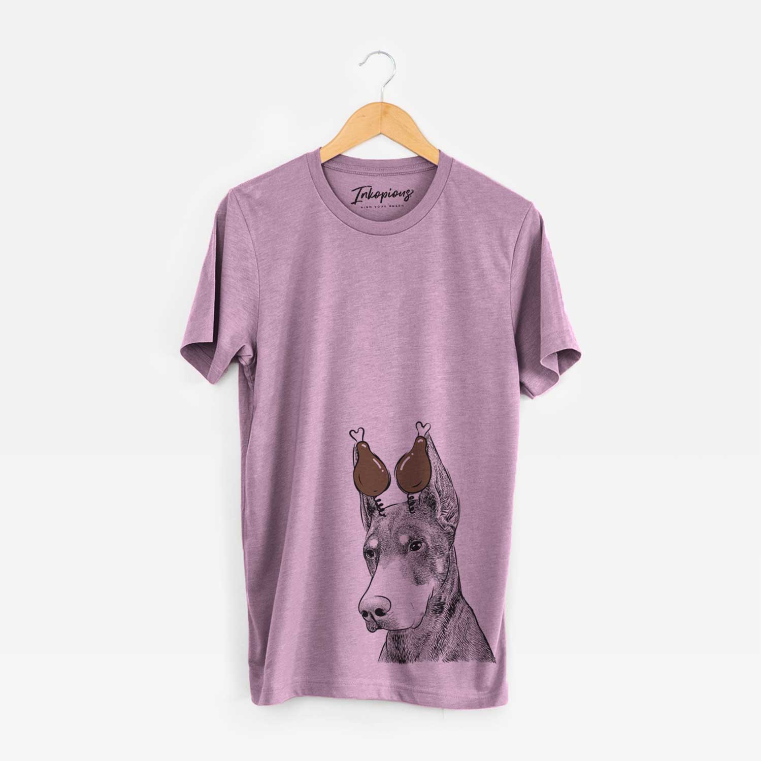 Hand-drawn sketch of Sunny the Doberman Pinscher with a Thanksgiving turkey headpiece on an Orchid Unisex crewneck