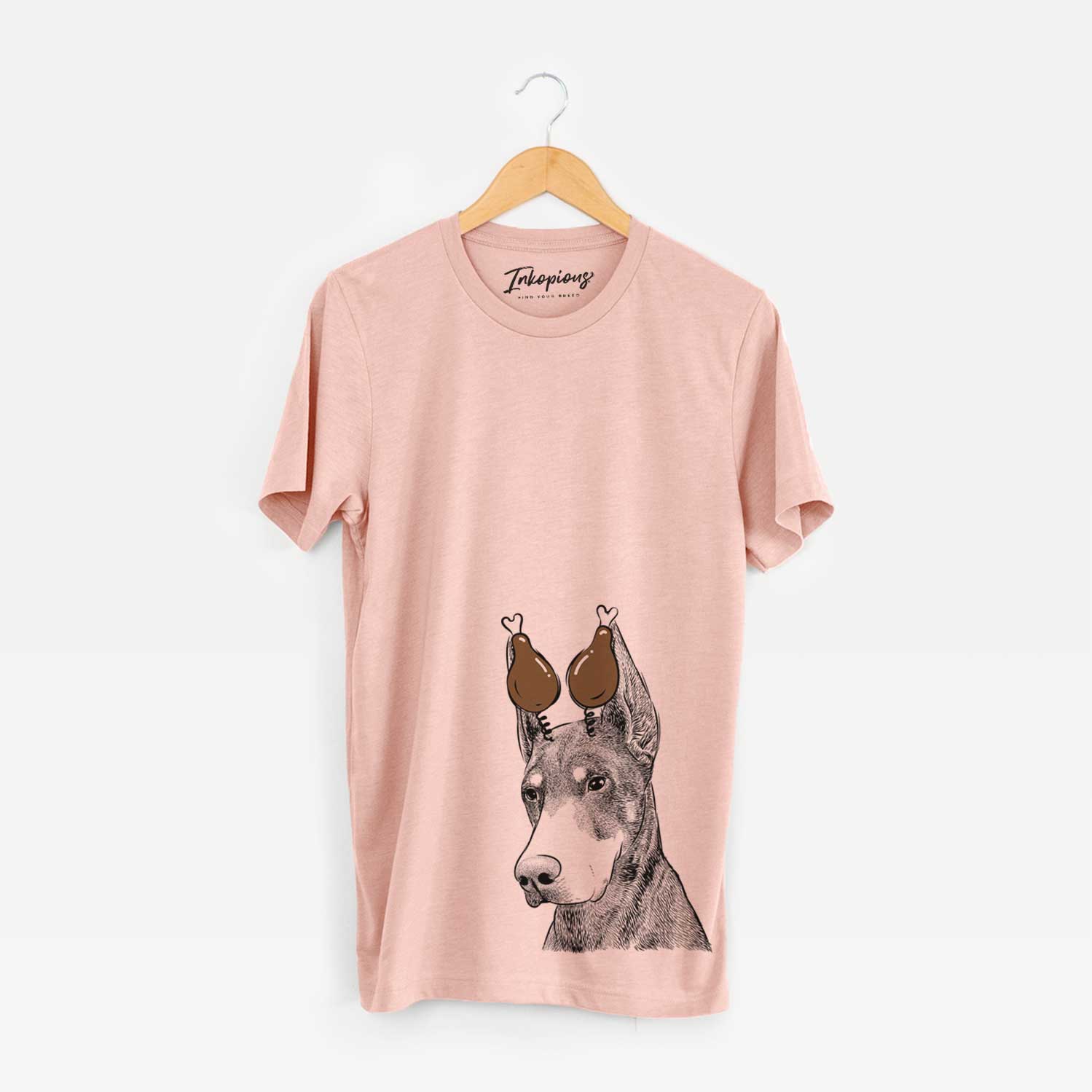 Hand-drawn sketch of Sunny the Doberman Pinscher with a Thanksgiving turkey headpiece on a Peach Unisex crewneck