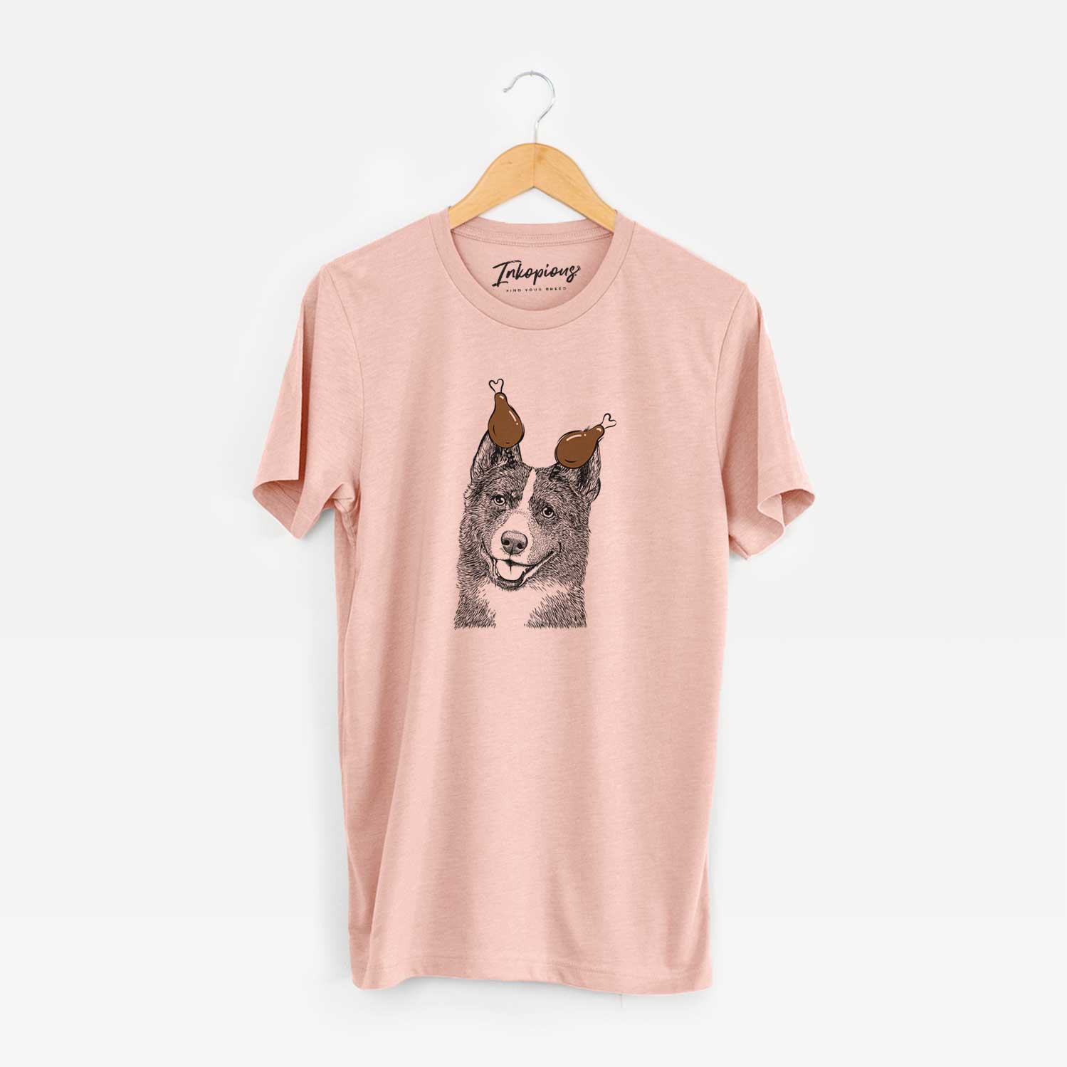Hand-drawn sketch of Tosca the Karelian Bear Dog with a Thanksgiving turkey headpiece on a Peach Unisex crewneck