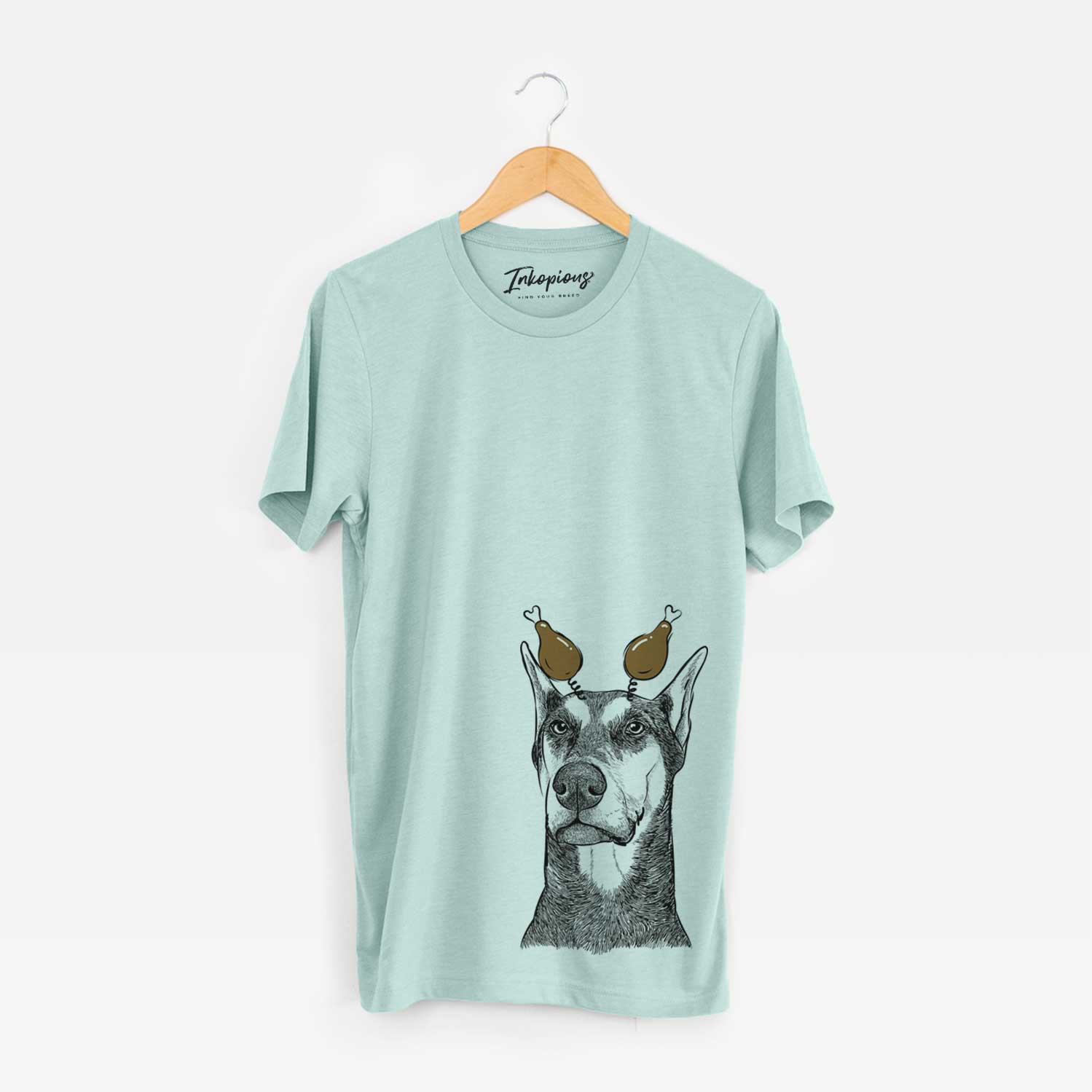 Hand-drawn sketch of Zeus the Doberman Pinscher with a Thanksgiving turkey headpiece on a Heather Sage Unisex crewneck