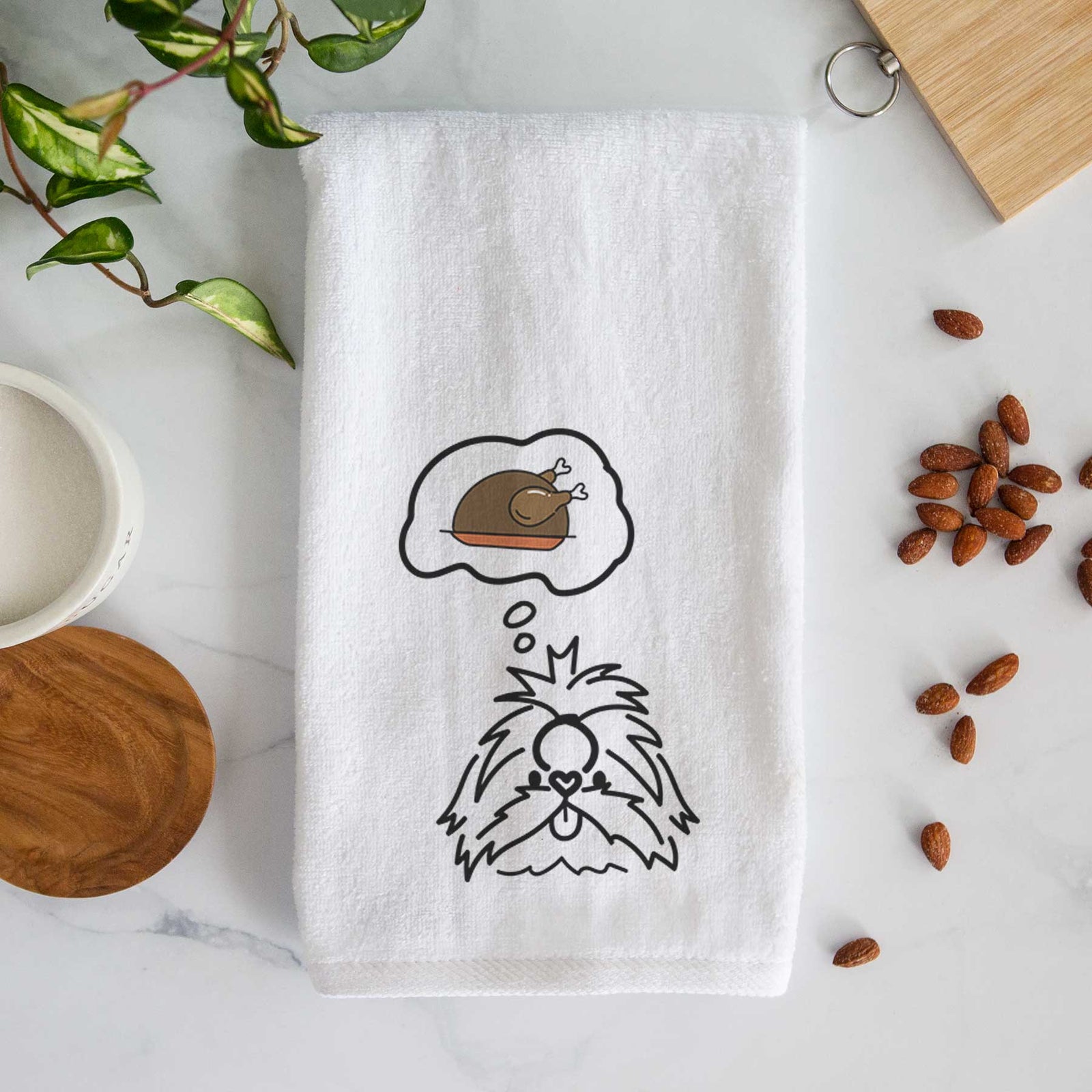 Minimalist line drawing of CoCo the Shih Tzu with a little turkey on a decorative hand towel