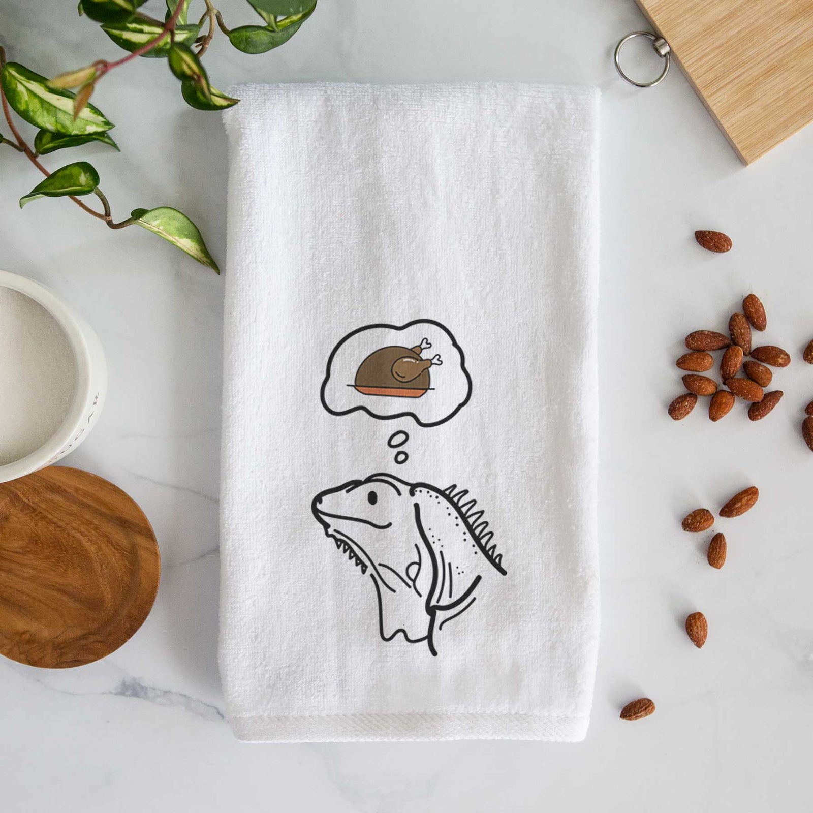 Minimalist line drawing of Louie the Iguana with a little turkey on a decorative hand towel