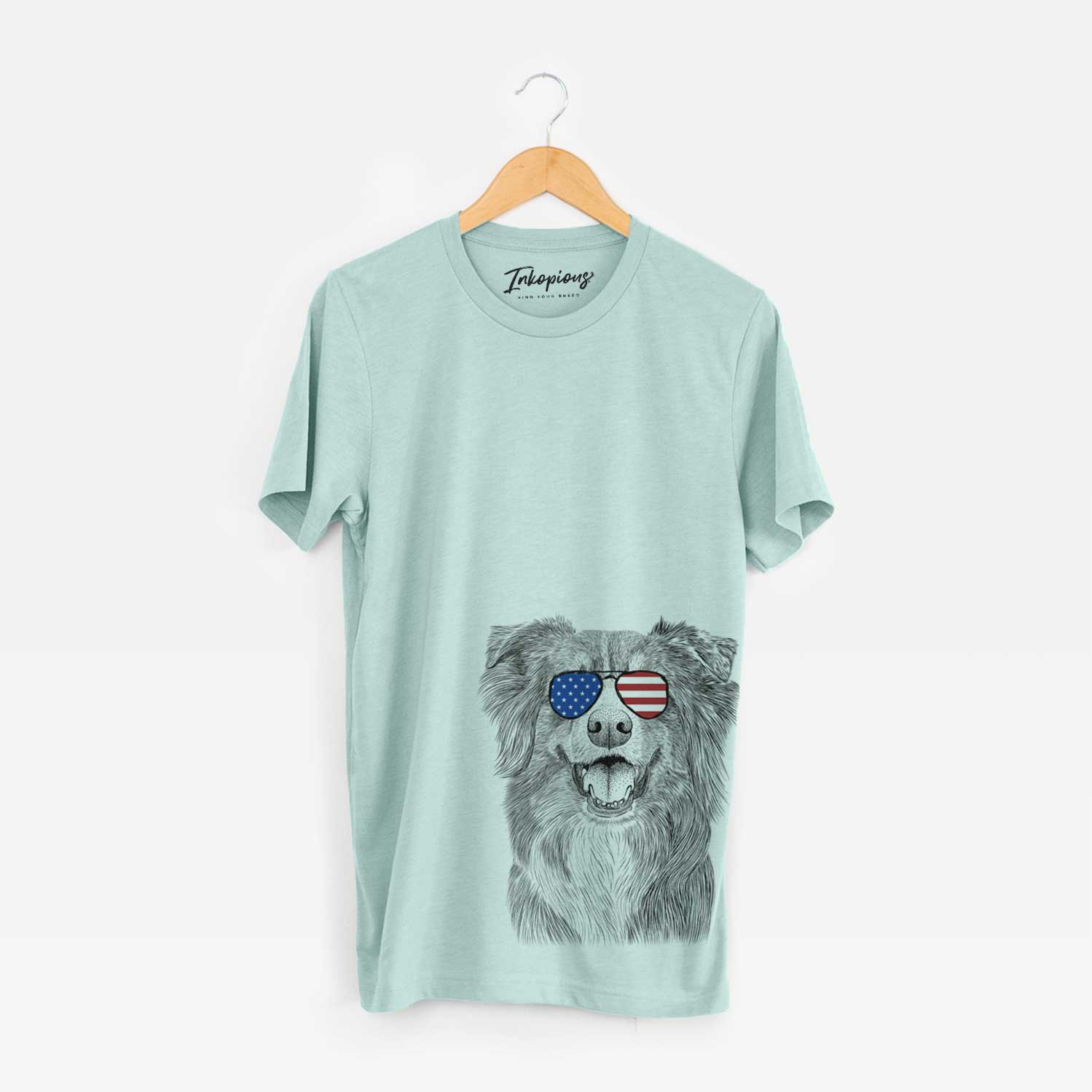 Hand-drawn sketch of Aussie Parker the Australian Shepherd wearing American flag sunglasses on a Heather Sage Unisex crewneck