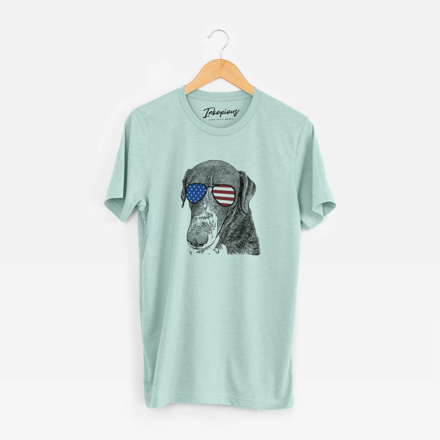 Hand-drawn sketch of Angel Orion the Mixed Breed wearing American flag sunglasses on a Heather Sage Unisex crewneck