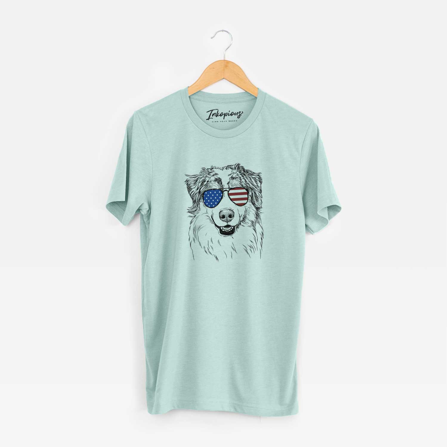 Hand-drawn sketch of Aonghus the Australian Shepherd wearing American flag sunglasses on a Heather Sage Unisex crewneck