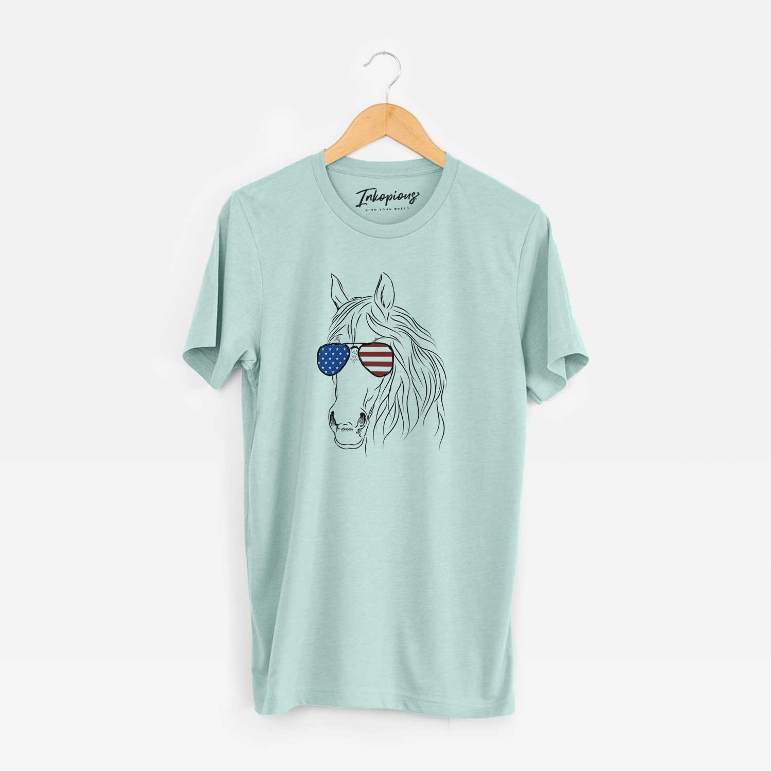 Hand-drawn sketch of Aria the Horse wearing American flag sunglasses on a Heather Sage Unisex crewneck