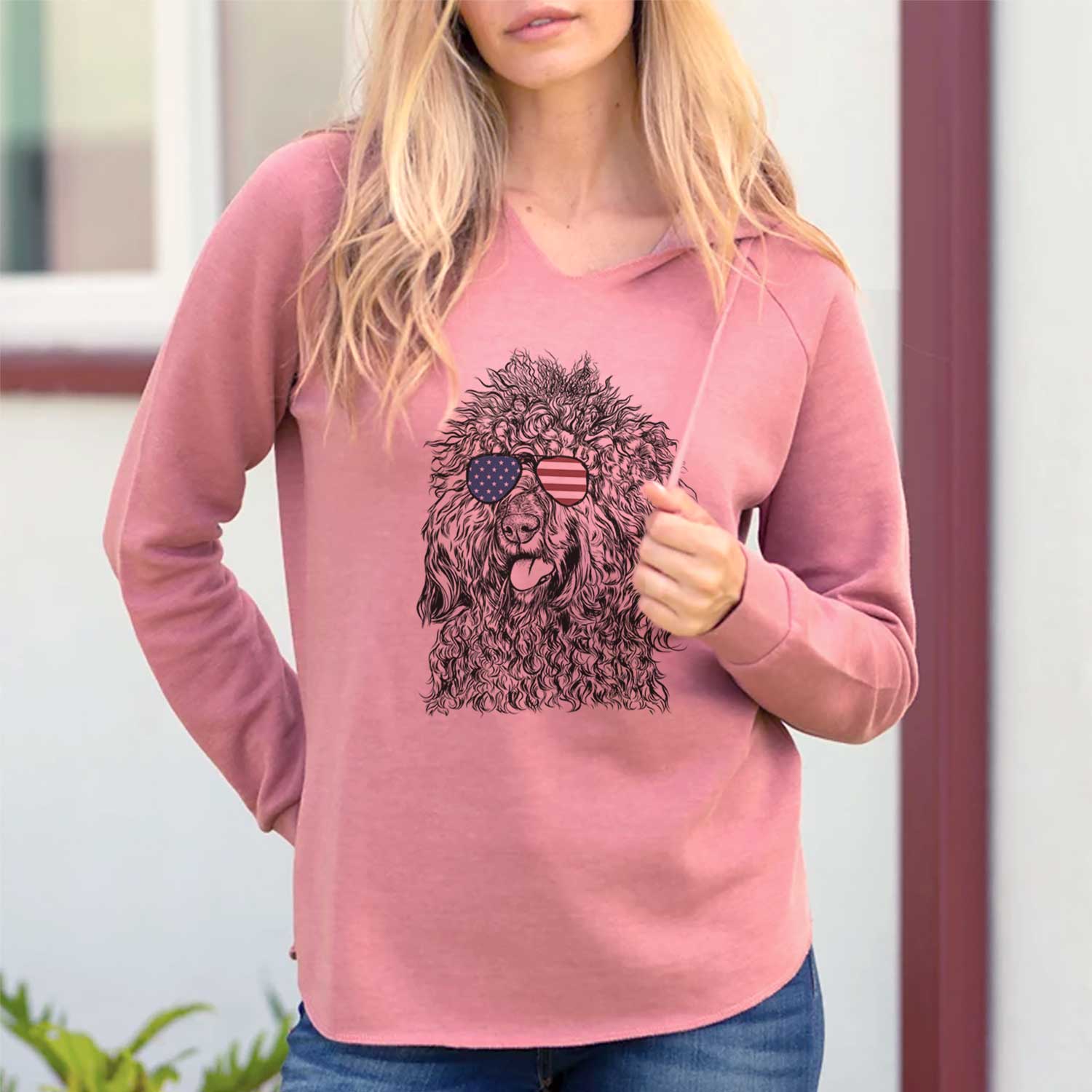 Hand-drawn sketch of Babs the Barbet wearing American flag sunglasses on a Dusty Rose Cali Wave Hooded Sweatshirt, lifestyle photo