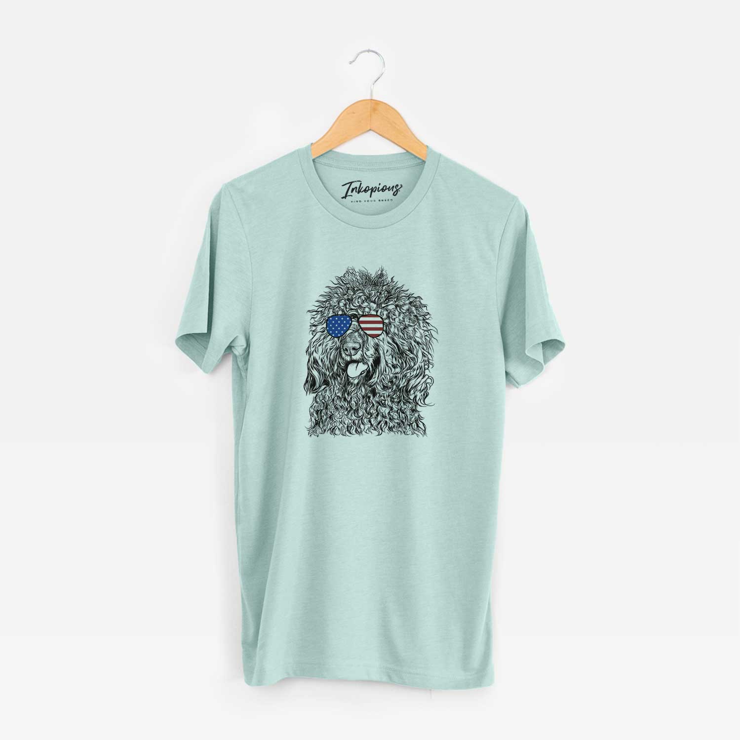 Hand-drawn sketch of Babs the Barbet wearing American flag sunglasses on a Heather Sage Unisex crewneck