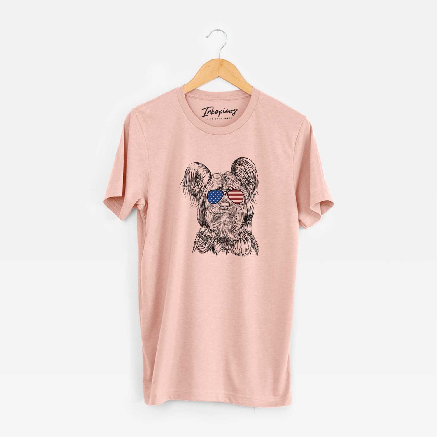 Hand-drawn sketch of Bandit the Skye Terrier wearing American flag sunglasses on a Peach Unisex crewneck