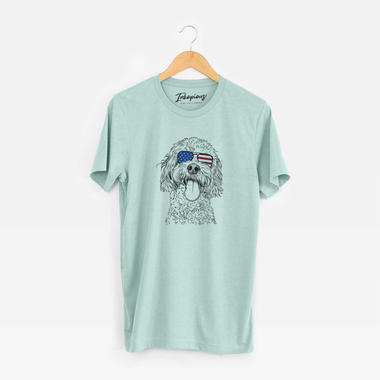 Hand-drawn sketch of Barney the Cavachon wearing American flag sunglasses on a Heather Sage Unisex crewneck