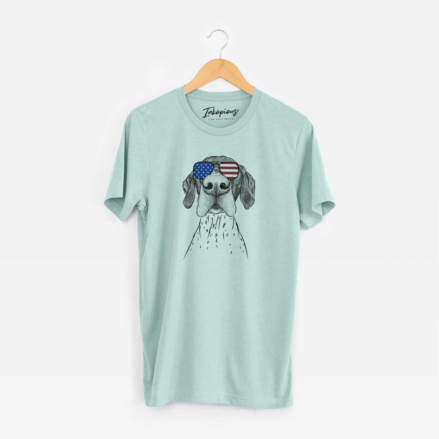 Hand-drawn sketch of Booze the German Shorthaired Pointer wearing American flag sunglasses on a Heather Sage Unisex crewneck