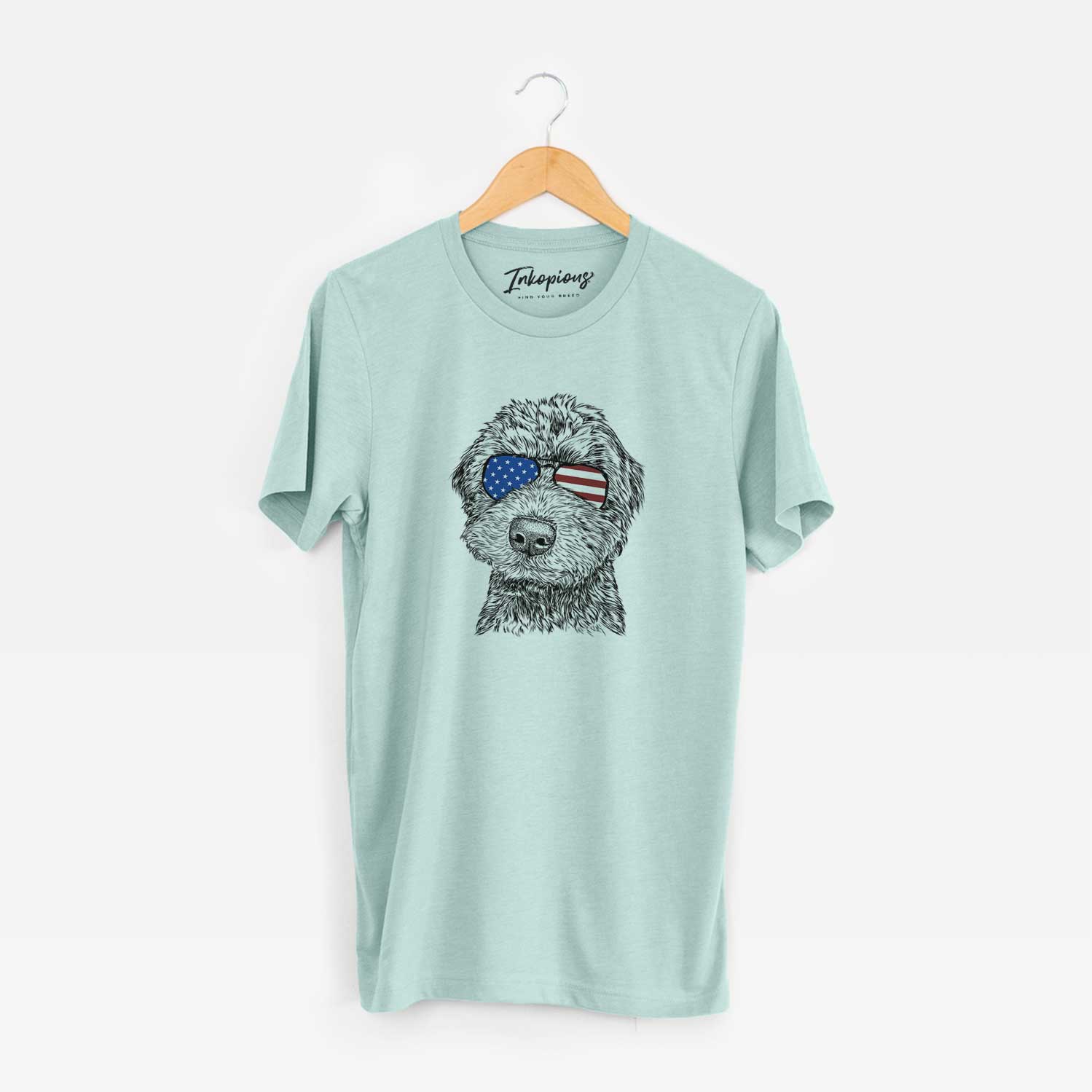 Hand-drawn sketch of Bowser the Whoodle wearing American flag sunglasses on a Heather Sage Unisex crewneck