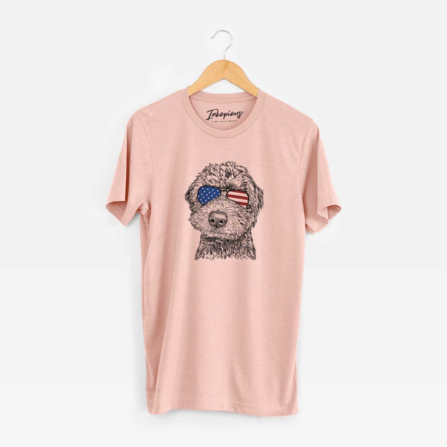 Hand-drawn sketch of Bowser the Whoodle wearing American flag sunglasses on a Peach Unisex crewneck