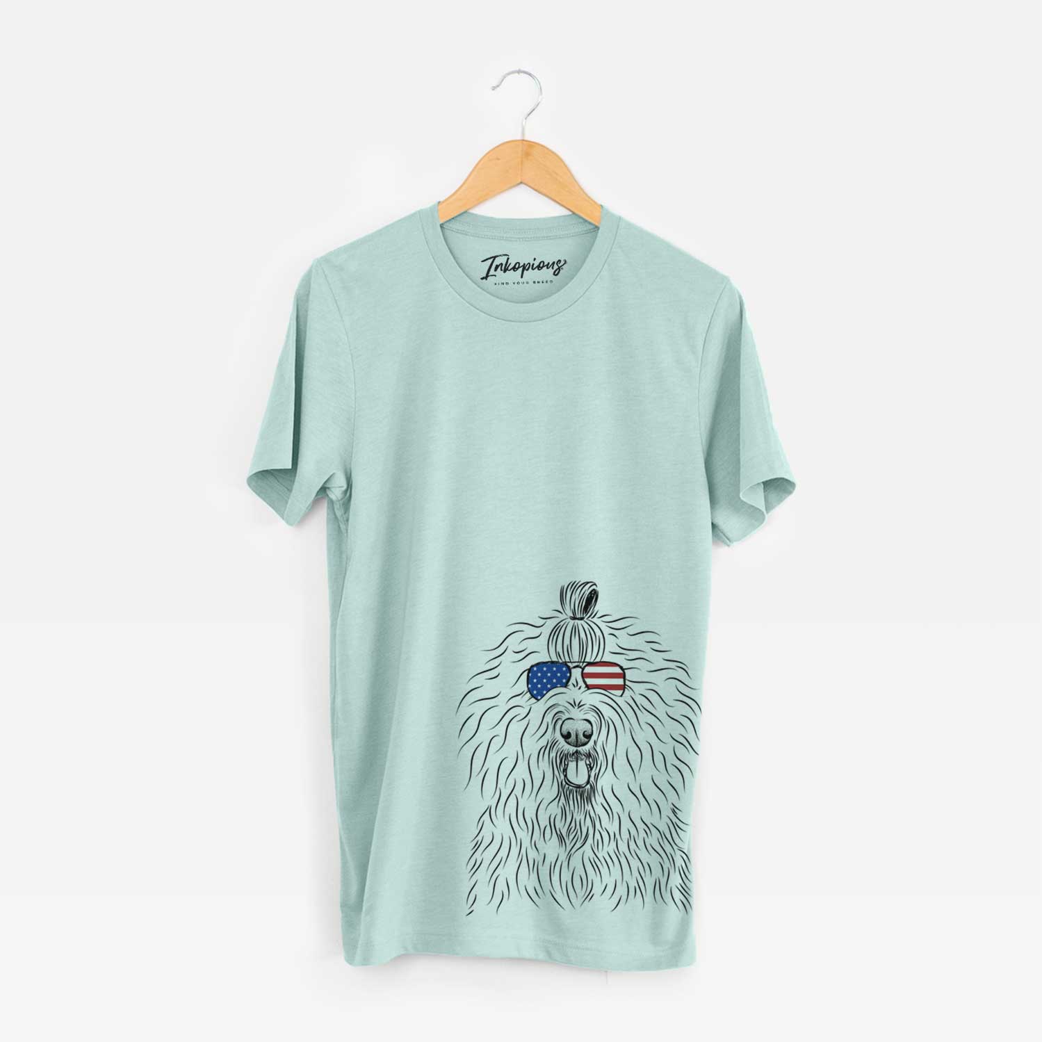 Hand-drawn sketch of Brody the Old English Sheepdog wearing American flag sunglasses on a Heather Sage Unisex crewneck