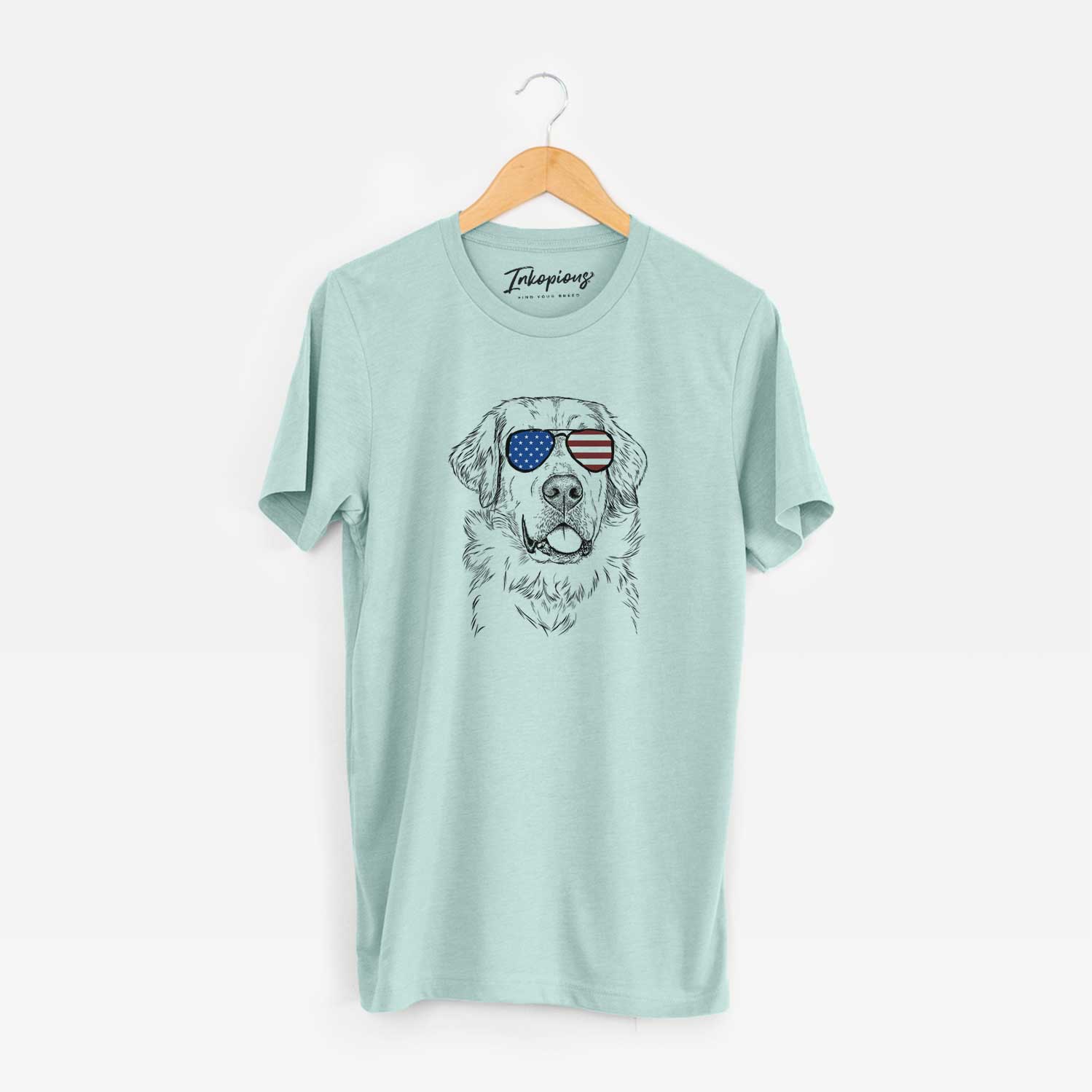 Hand-drawn sketch of Brophy the Great Pyrenees wearing American flag sunglasses on a Heather Sage Unisex crewneck