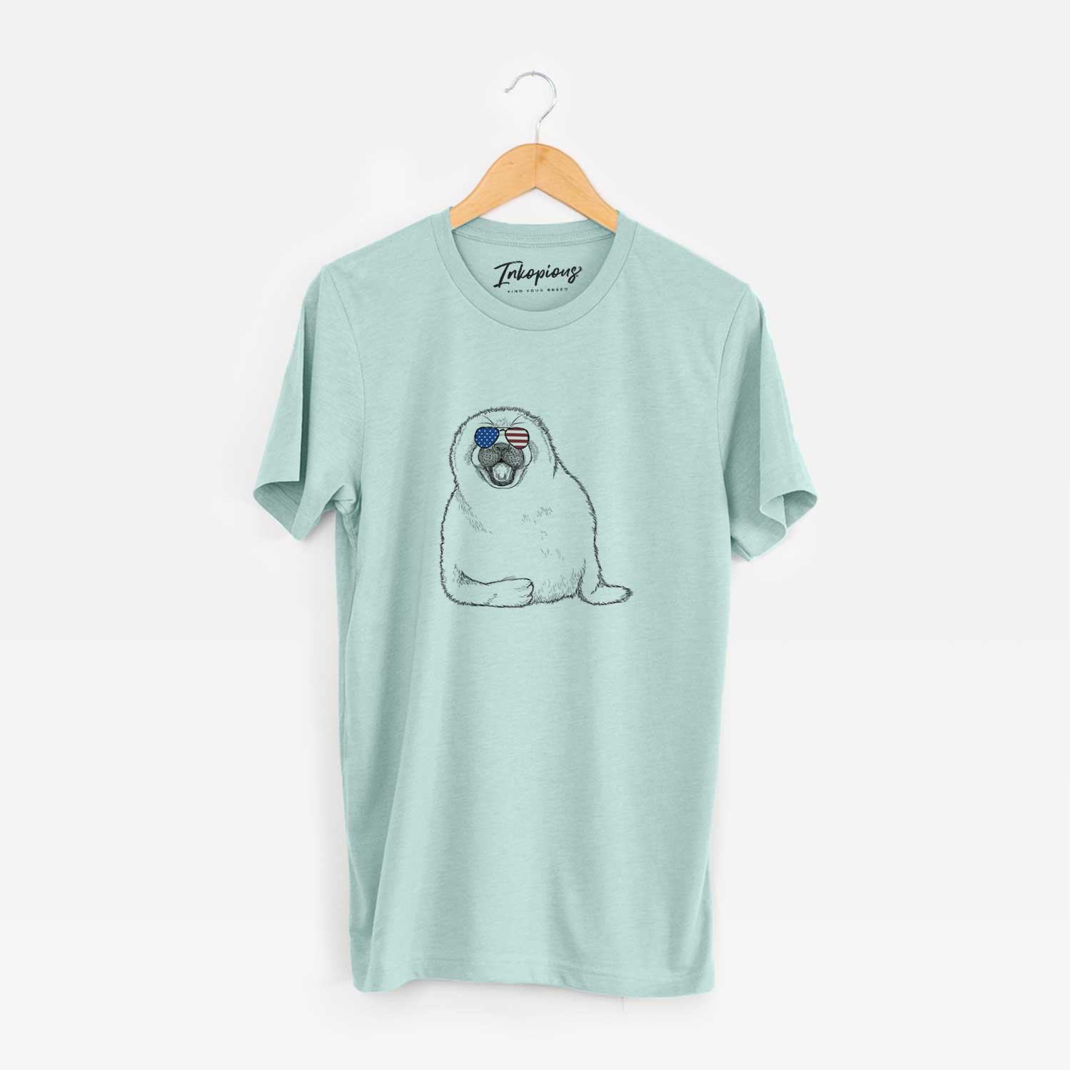 Hand-drawn sketch of Bub the Harp Seal wearing American flag sunglasses on a Heather Sage Unisex crewneck