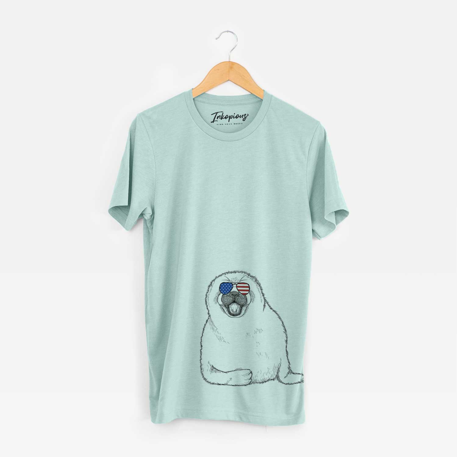 Hand-drawn sketch of Bub the Harp Seal wearing American flag sunglasses on a Heather Sage Unisex crewneck