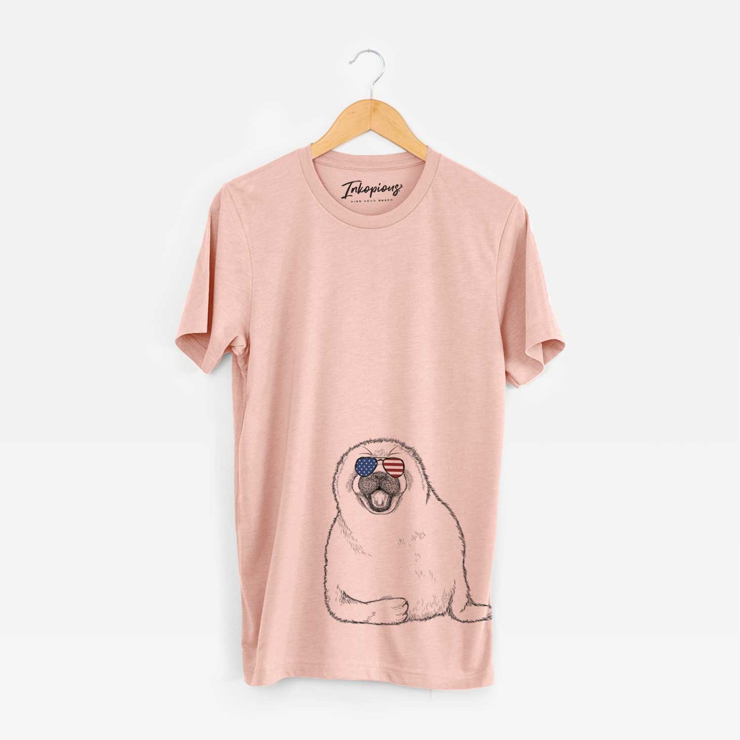 Hand-drawn sketch of Bub the Harp Seal wearing American flag sunglasses on a Peach Unisex crewneck