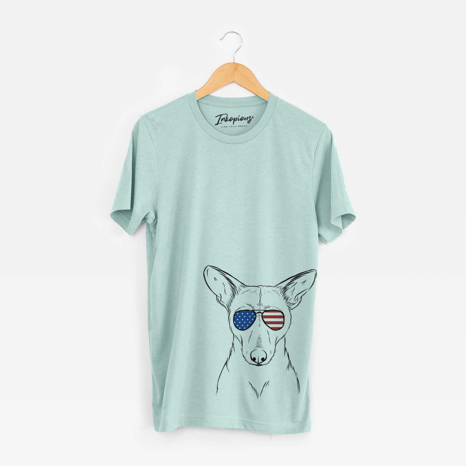 Hand-drawn sketch of Buff the Dorgi wearing American flag sunglasses on a Heather Sage Unisex crewneck