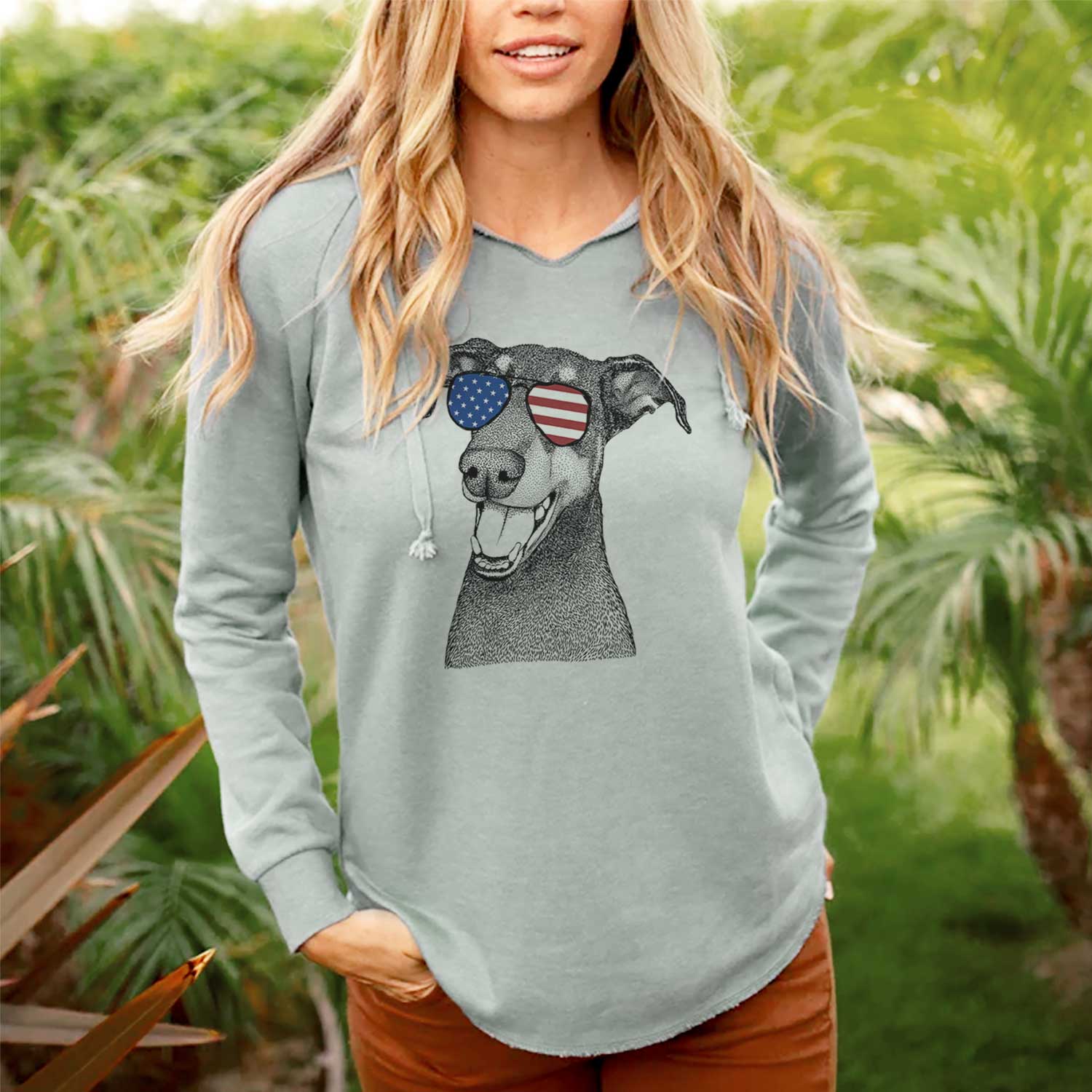 Hand-drawn sketch of Bunnie the Doberman Pinscher wearing American flag sunglasses on a Sage Cali Wave Hooded Sweatshirt, lifestyle photo
