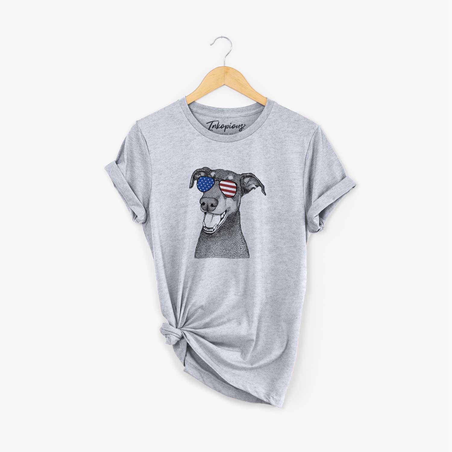 Hand-drawn sketch of Bunnie the Doberman Pinscher wearing American flag sunglasses on a Grey Unisex crewneck