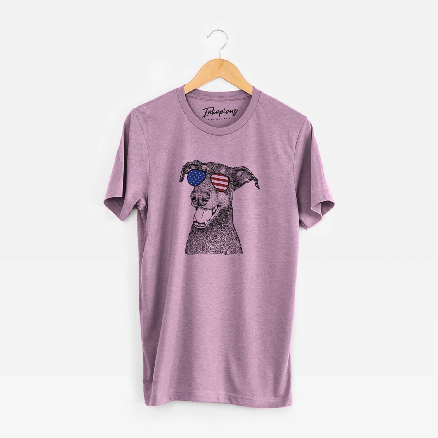 Hand-drawn sketch of Bunnie the Doberman Pinscher wearing American flag sunglasses on an Orchid Unisex crewneck
