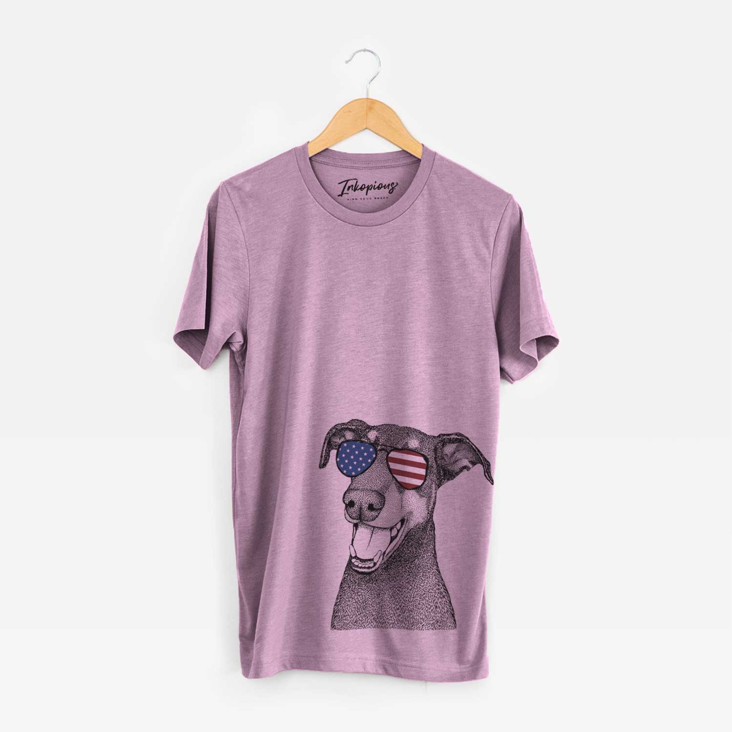 Hand-drawn sketch of Bunnie the Doberman Pinscher wearing American flag sunglasses on an Orchid Unisex crewneck