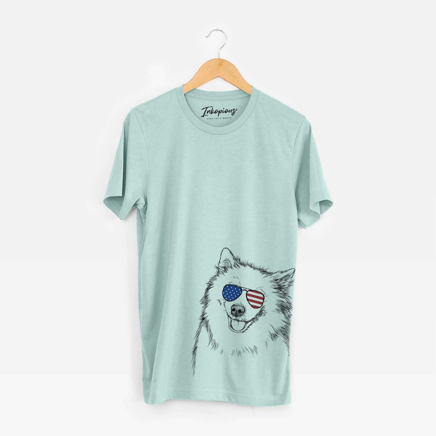 Hand-drawn sketch of Caico the Samoyed wearing American flag sunglasses on a Heather Sage Unisex crewneck