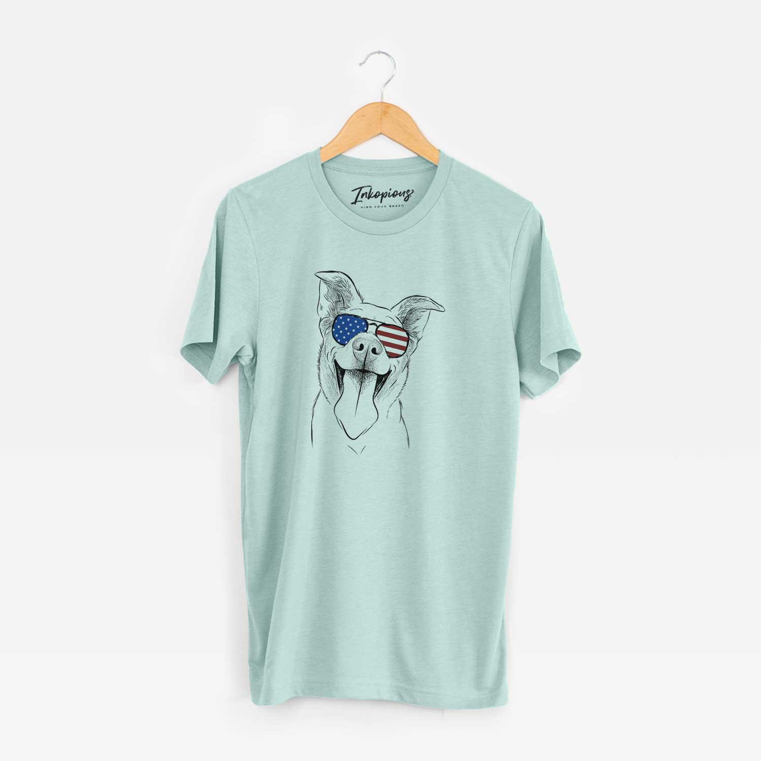 Hand-drawn sketch of Candy the Mixed Breed wearing American flag sunglasses on a Heather Sage Unisex crewneck