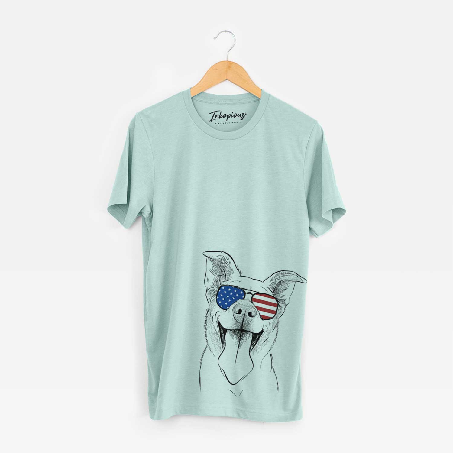 Hand-drawn sketch of Candy the Mixed Breed wearing American flag sunglasses on a Heather Sage Unisex crewneck