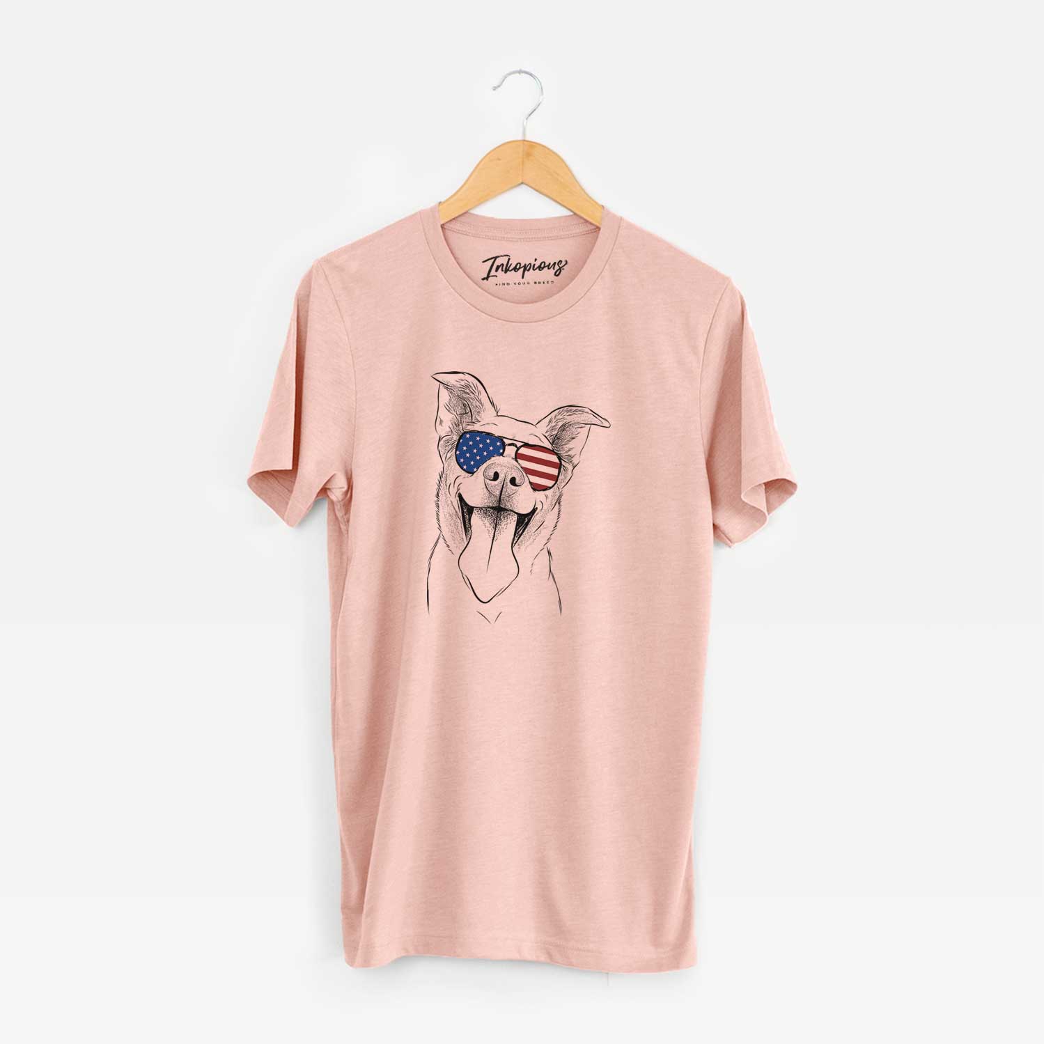 Hand-drawn sketch of Candy the Mixed Breed wearing American flag sunglasses on a Peach Unisex crewneck