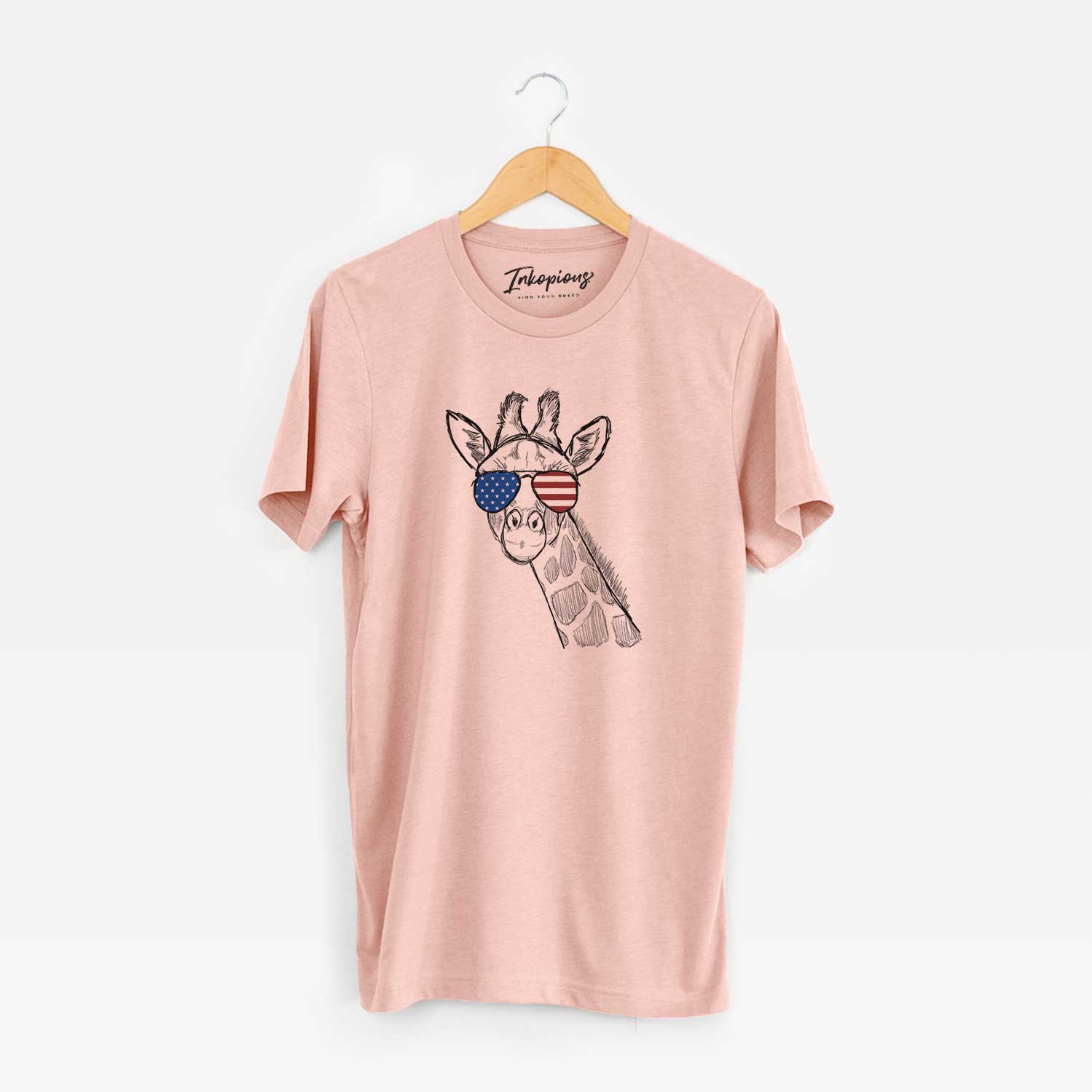 Hand-drawn sketch of Cedrick the Giraffe wearing American flag sunglasses on a Peach Unisex crewneck