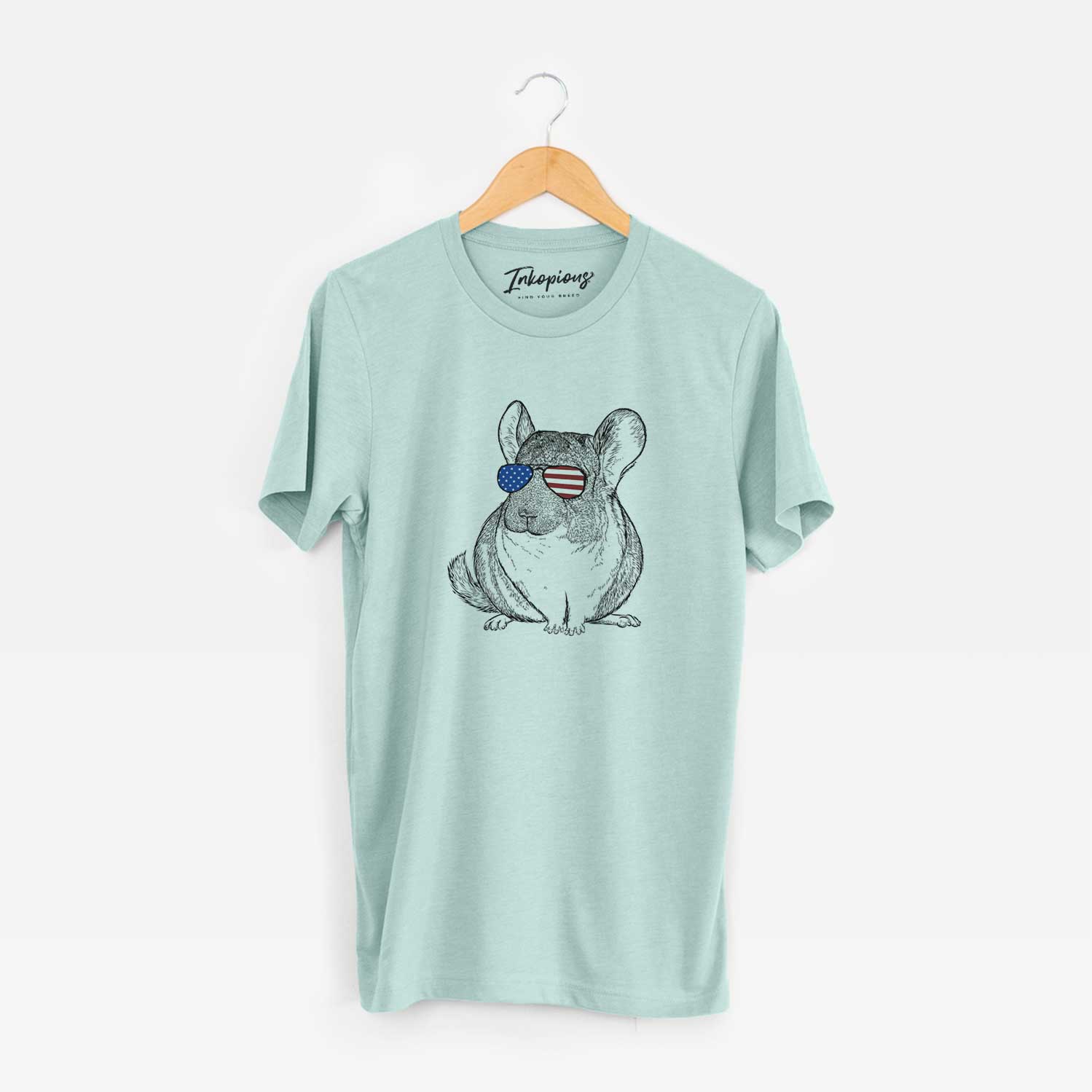 Hand-drawn sketch of Cheddar the Chinchilla wearing American flag sunglasses on a Heather Sage Unisex crewneck