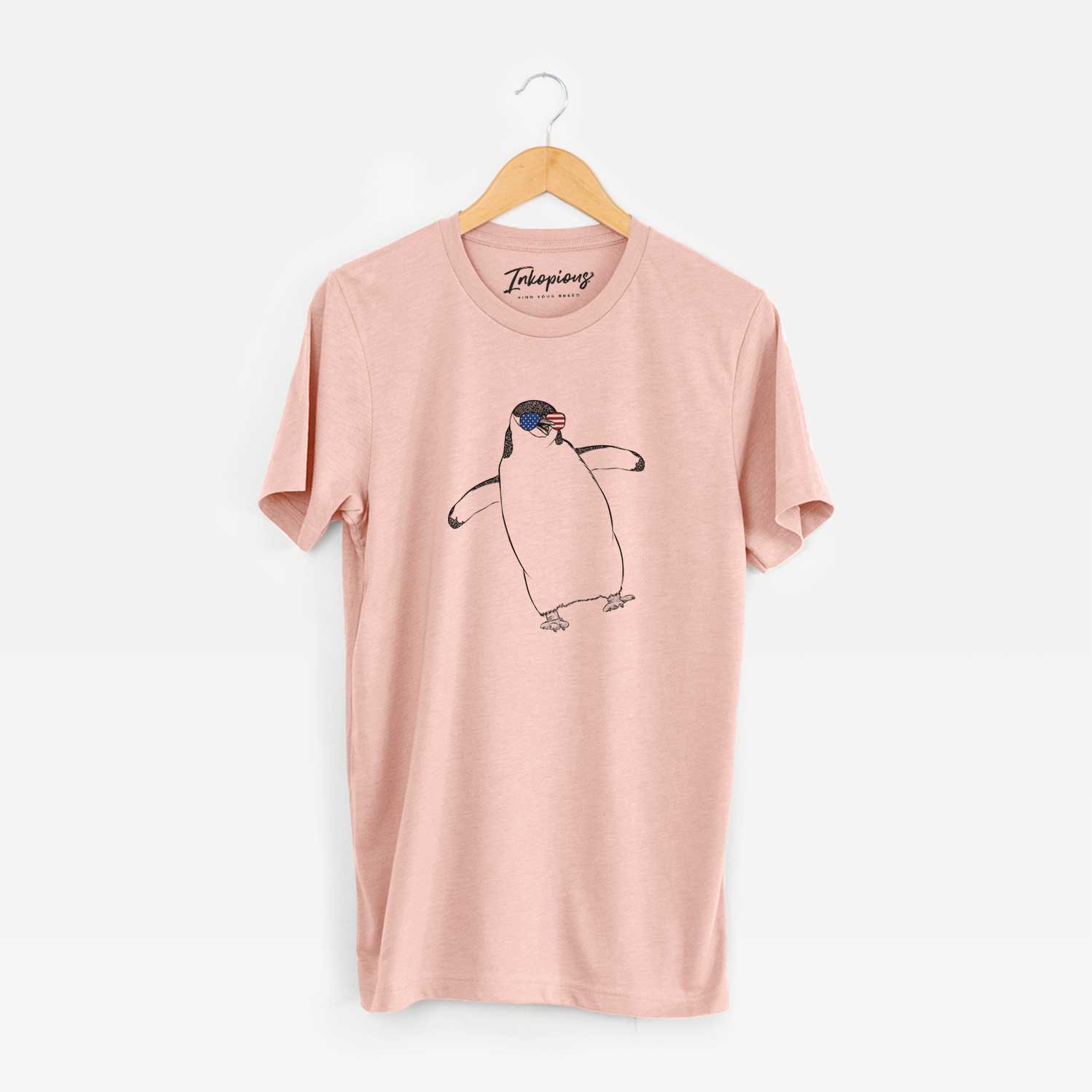 Hand-drawn sketch of Chive the Chinstrap Penguin wearing American flag sunglasses on a Peach Unisex crewneck