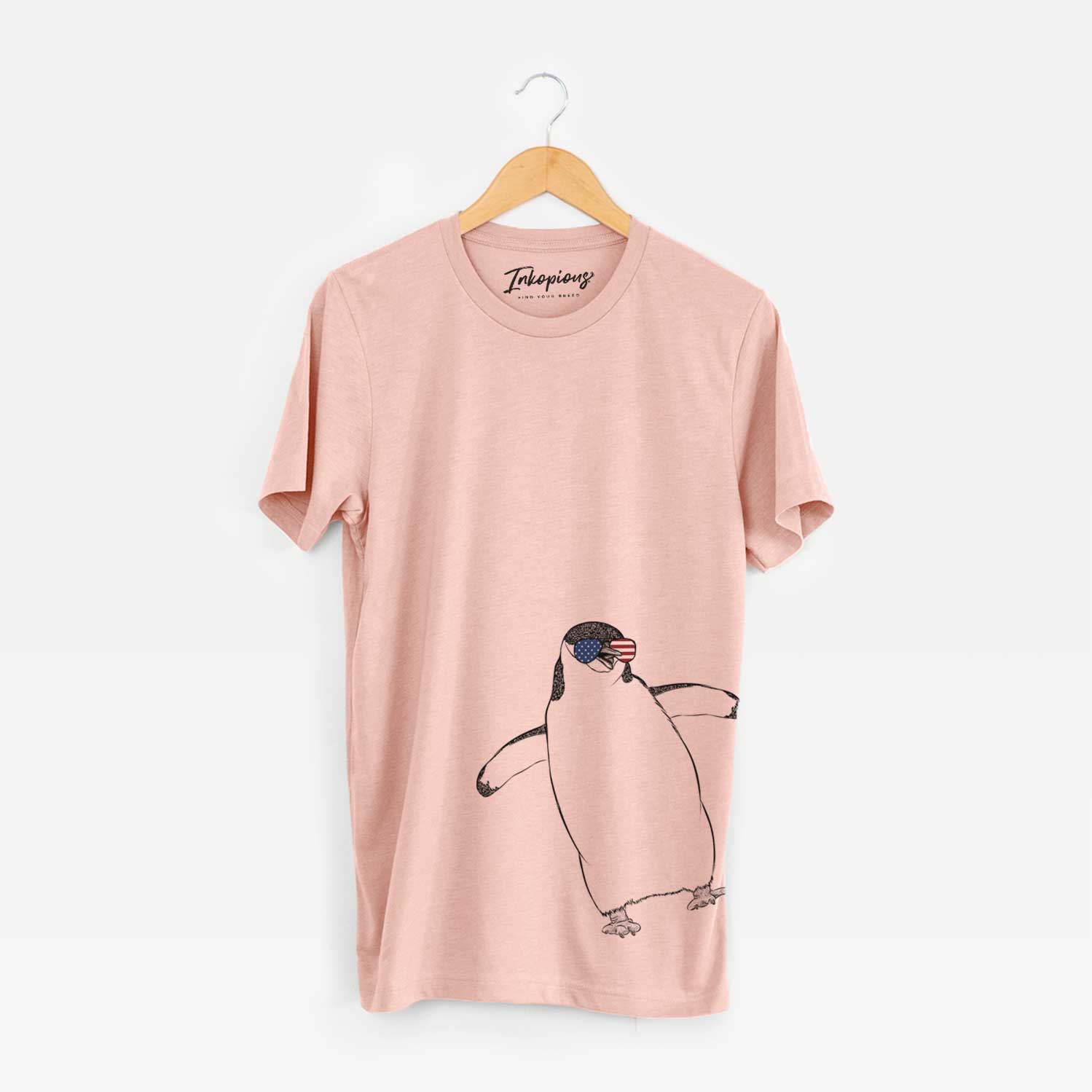Hand-drawn sketch of Chive the Chinstrap Penguin wearing American flag sunglasses on a Peach Unisex crewneck