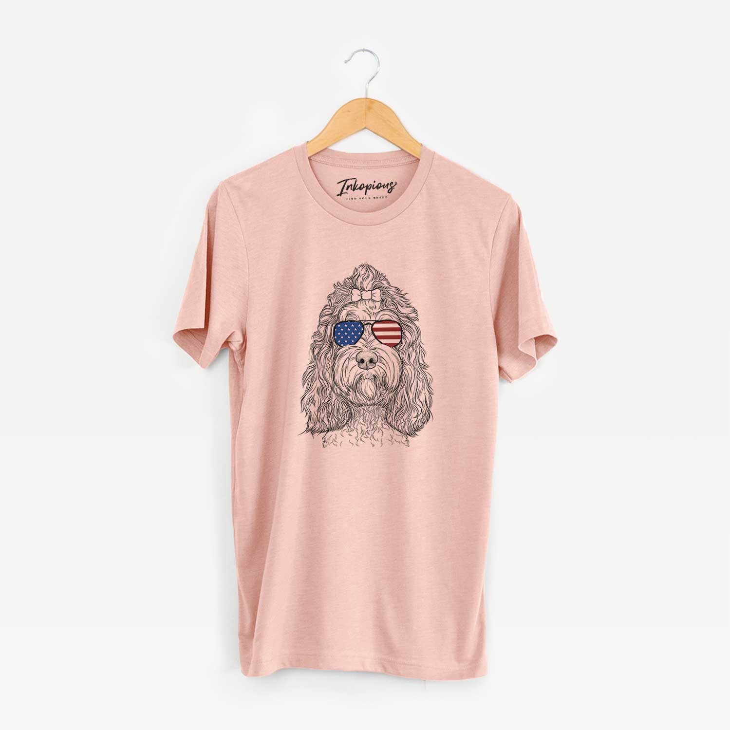 Hand-drawn sketch of Chloe the Cockapoo wearing American flag sunglasses on a Peach Unisex crewneck