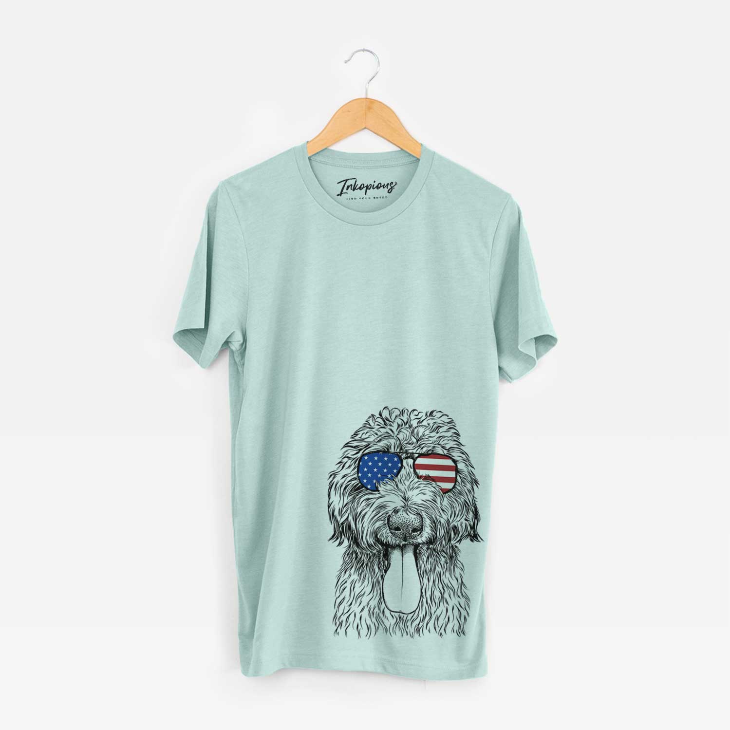 Hand-drawn sketch of CiCi Paulk the Aussiedoodle wearing American flag sunglasses on a Heather Sage Unisex crewneck